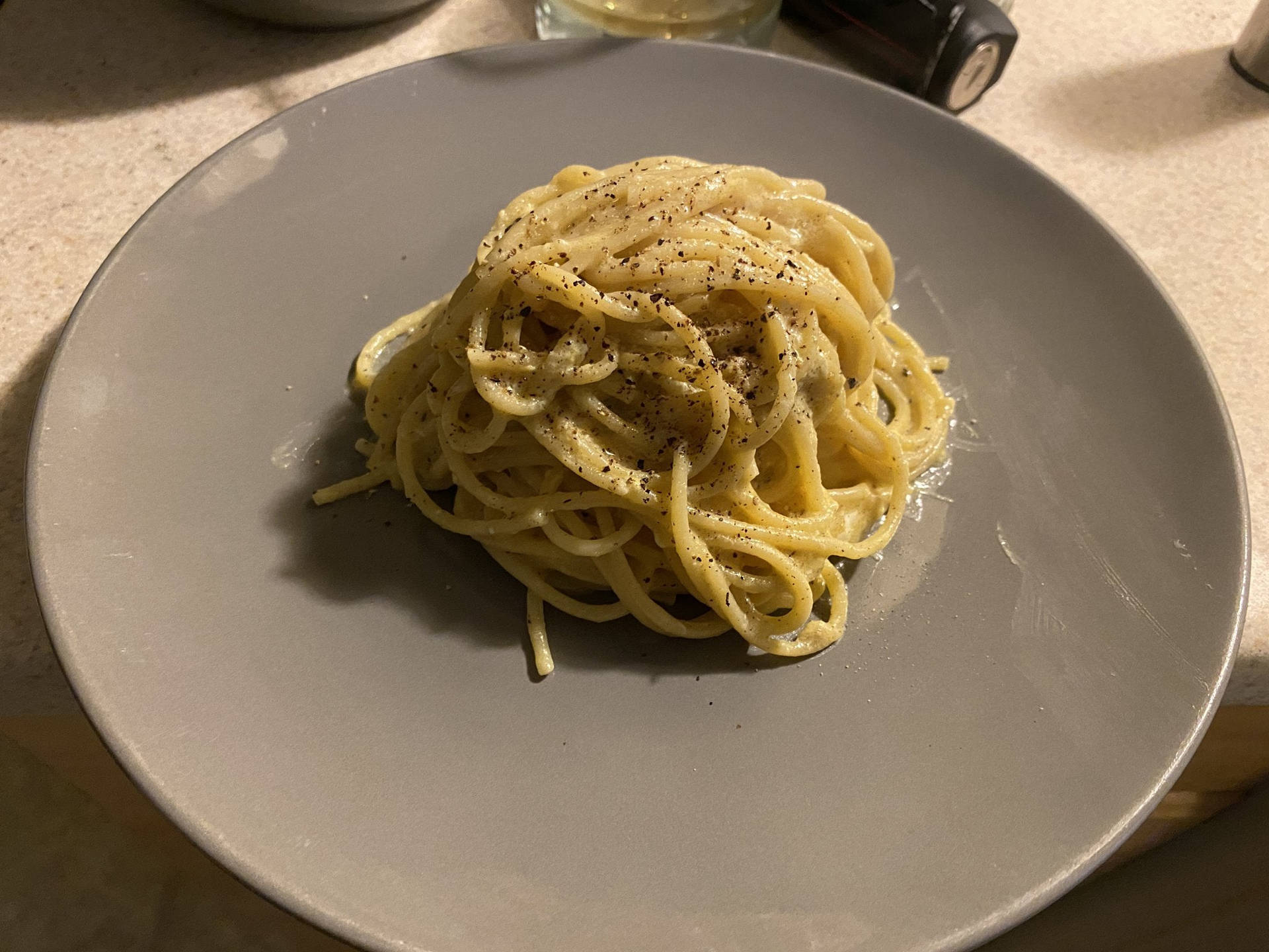 Grey Plate With A Small Serving Of Cacio E Pepe Background