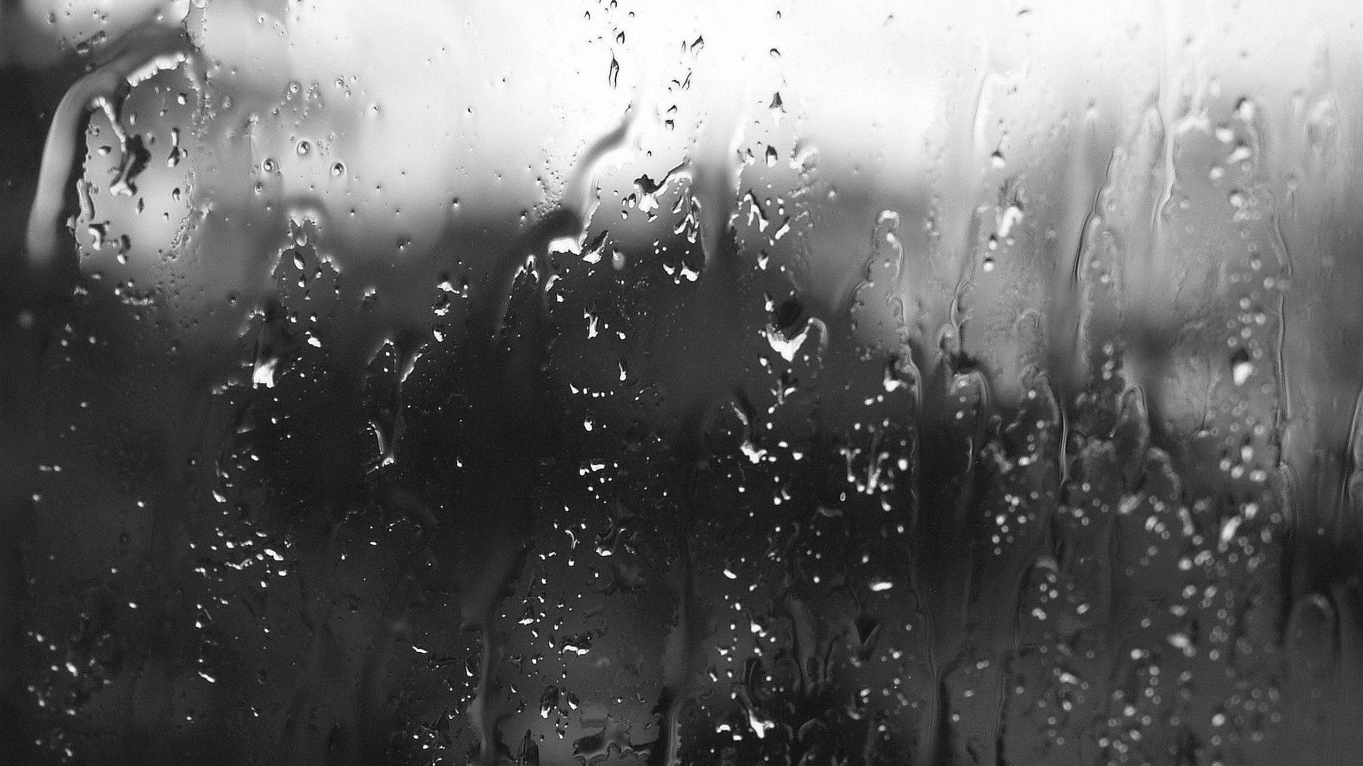 Greyscale Falling Raindrops On A Glass Pane Background