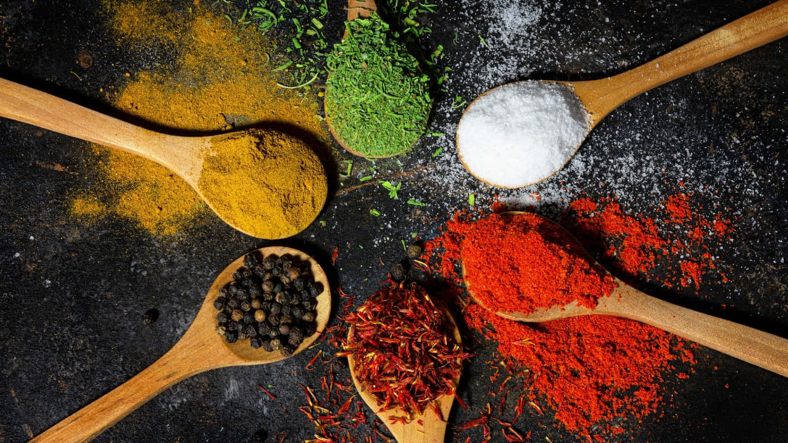 Ground And Minced Essential Cooking Spices On Wooden Spoons