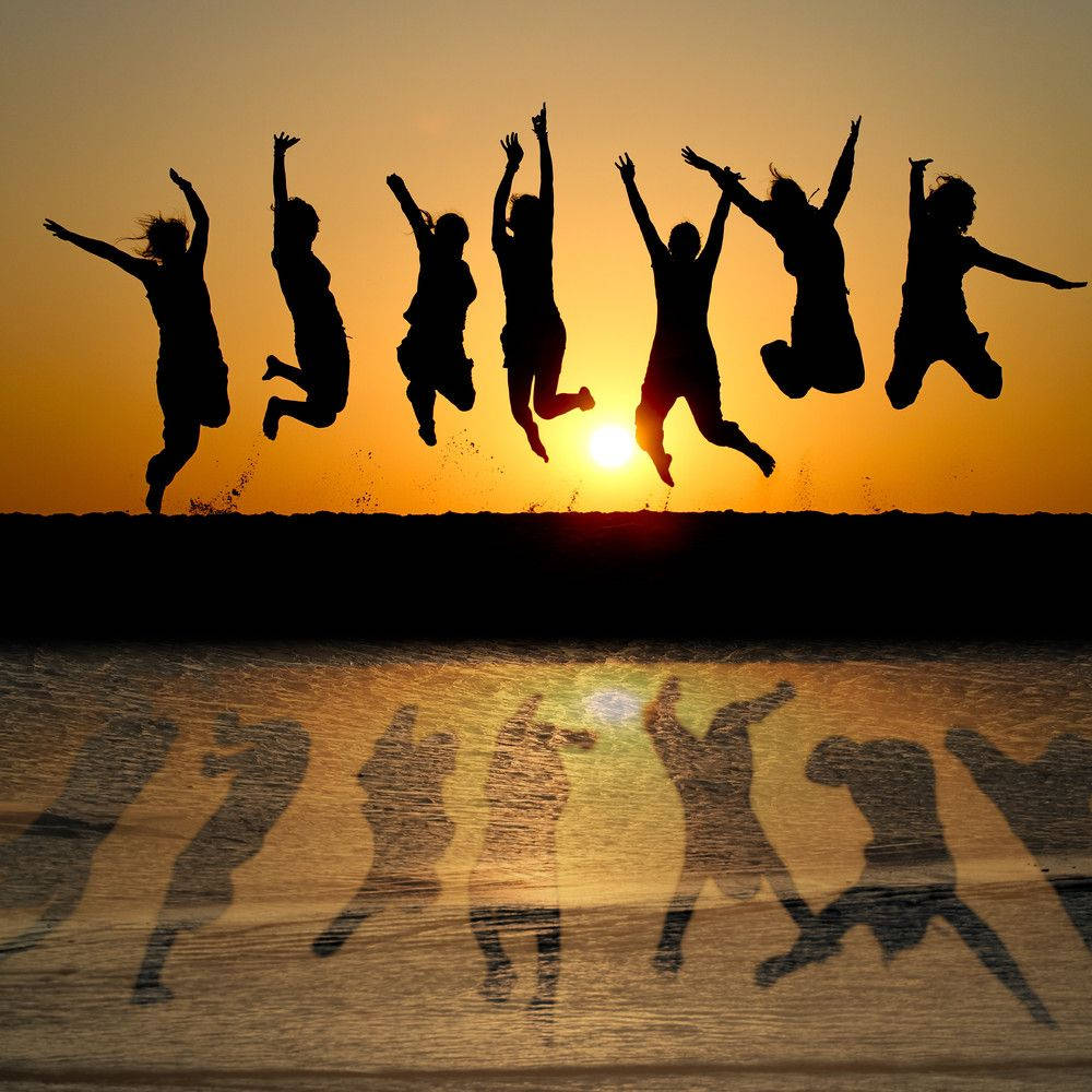 Group Jump Shot With Shadows Sunset Background