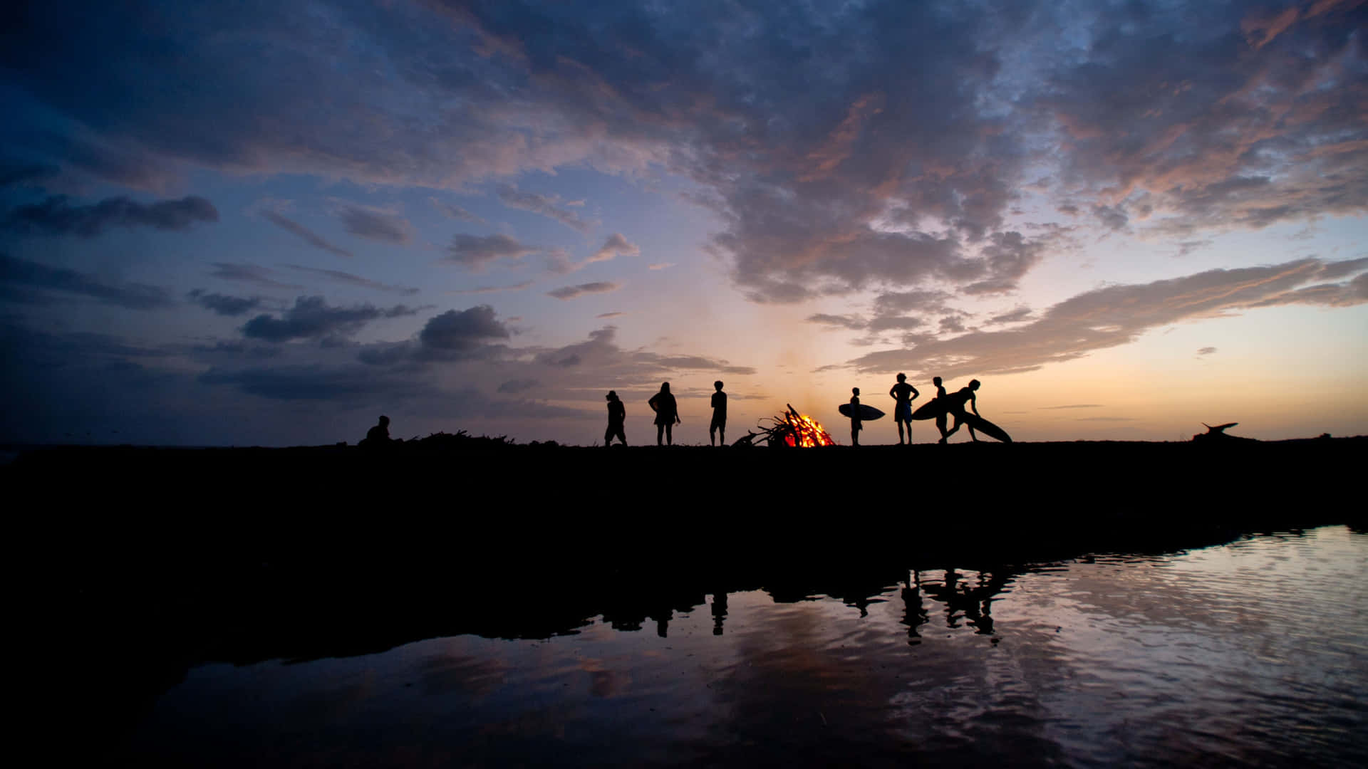 Group Of Friends Beside The Lake With Bonfire