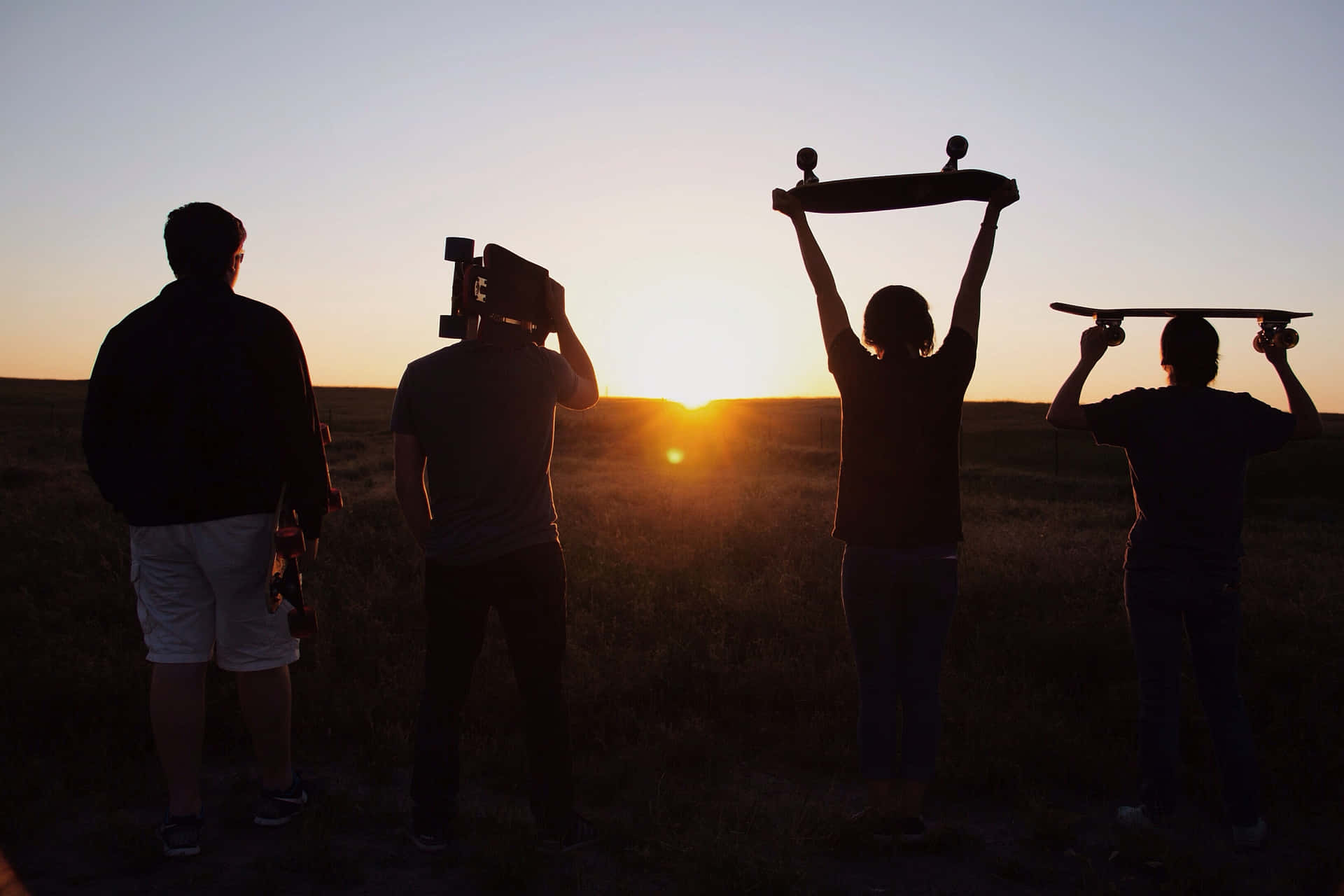 Group Of Friends Silhouette Holding Skateboards