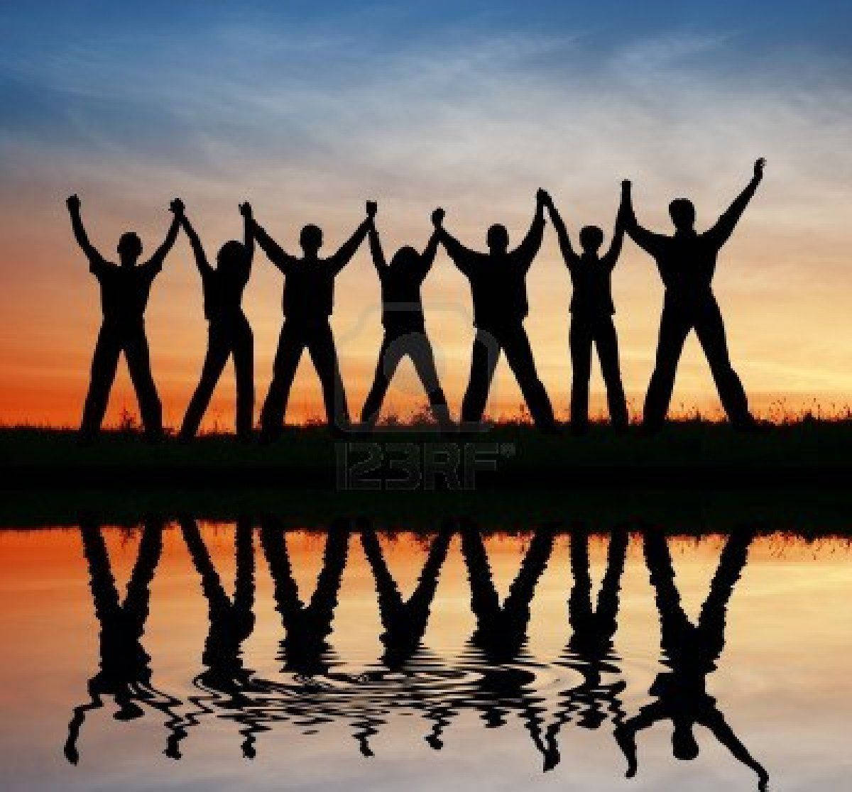 Group Raising Hands At Sunset Background