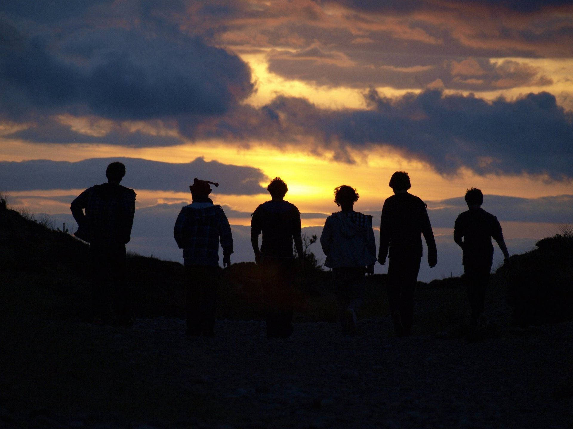 Group Silhouettes On Mountain Top Background