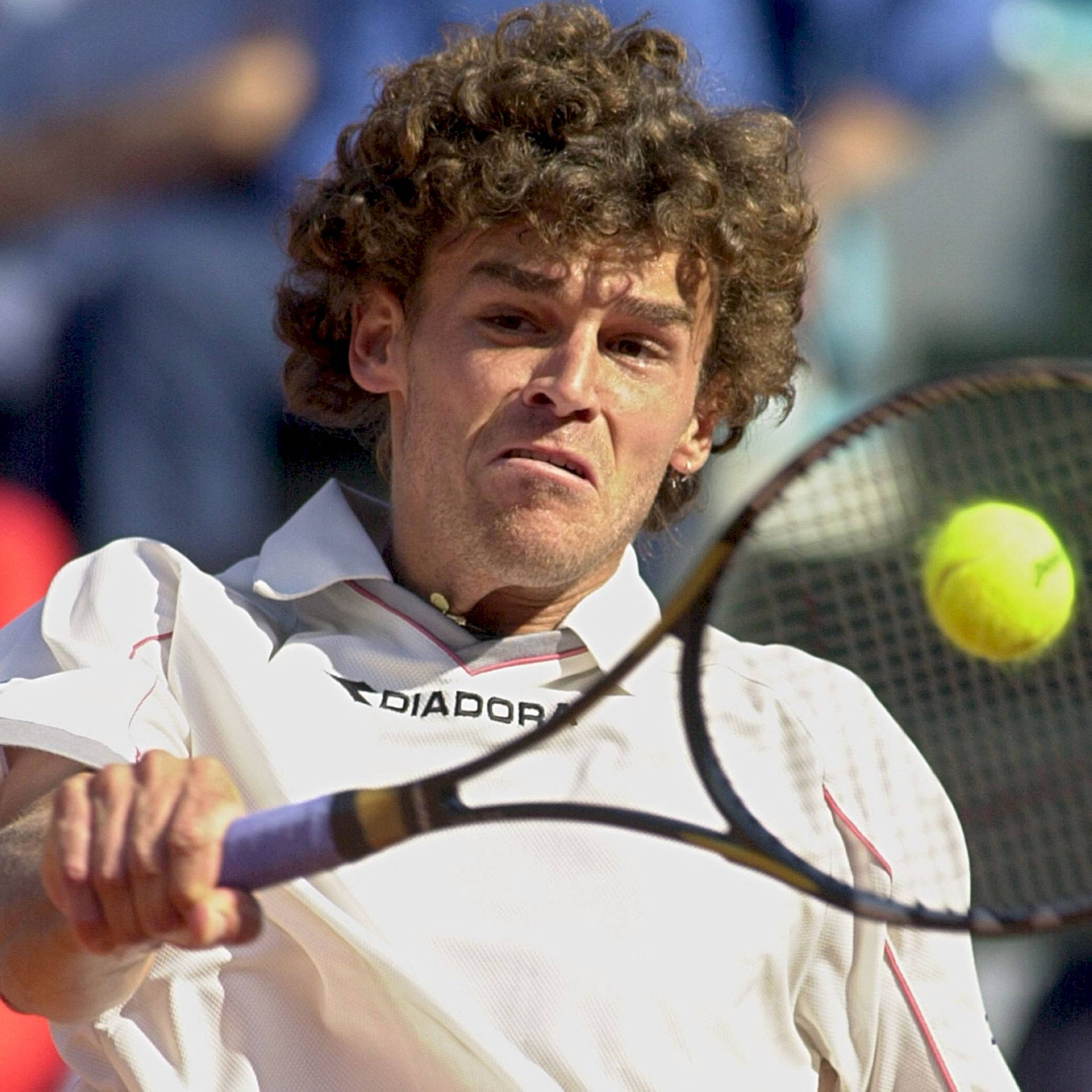 Gustavo Kuerten Executing A Backhand Stroke In A Tennis Match. Background