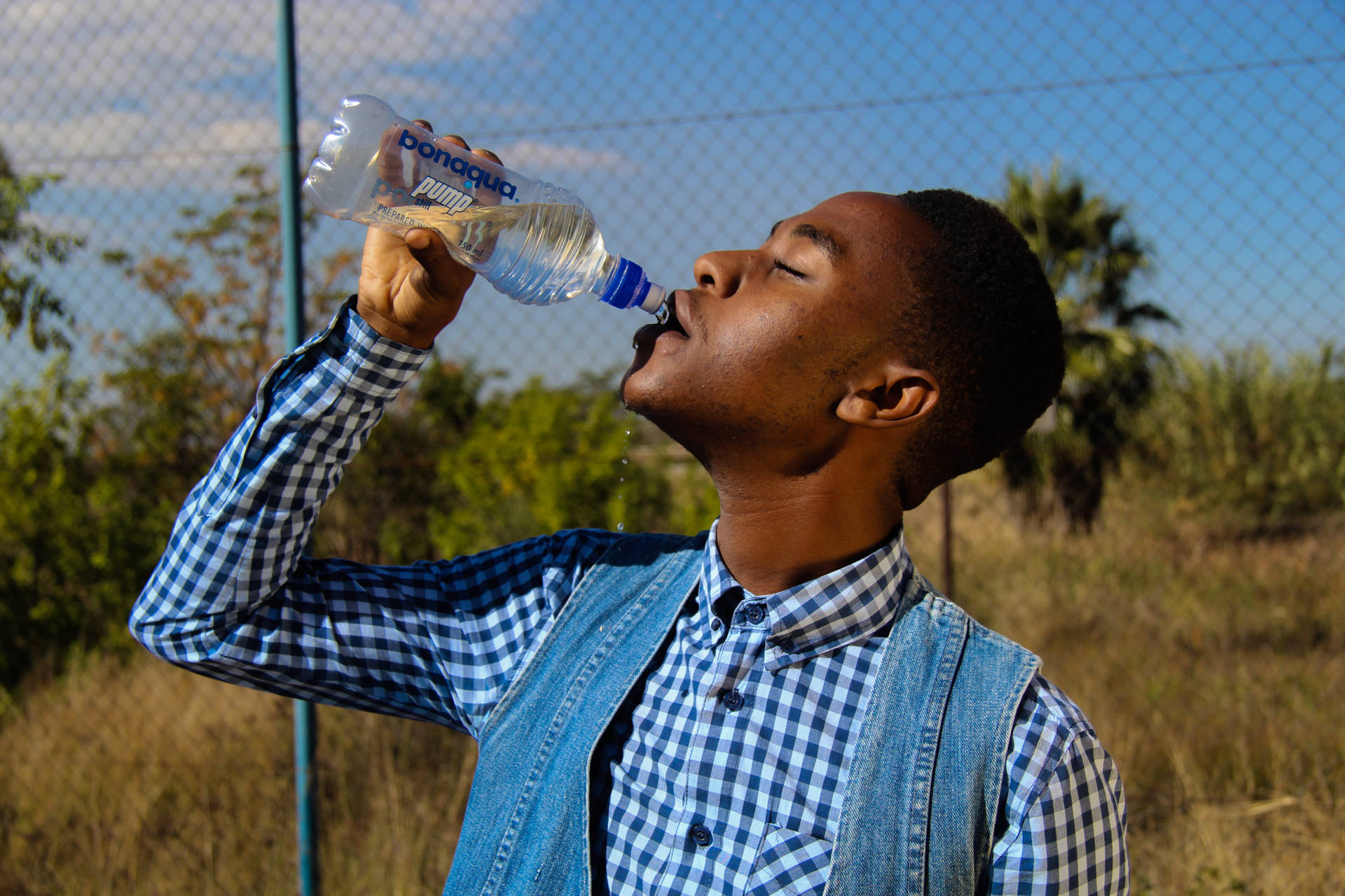 Guy Drinking Water From A Bottle Background