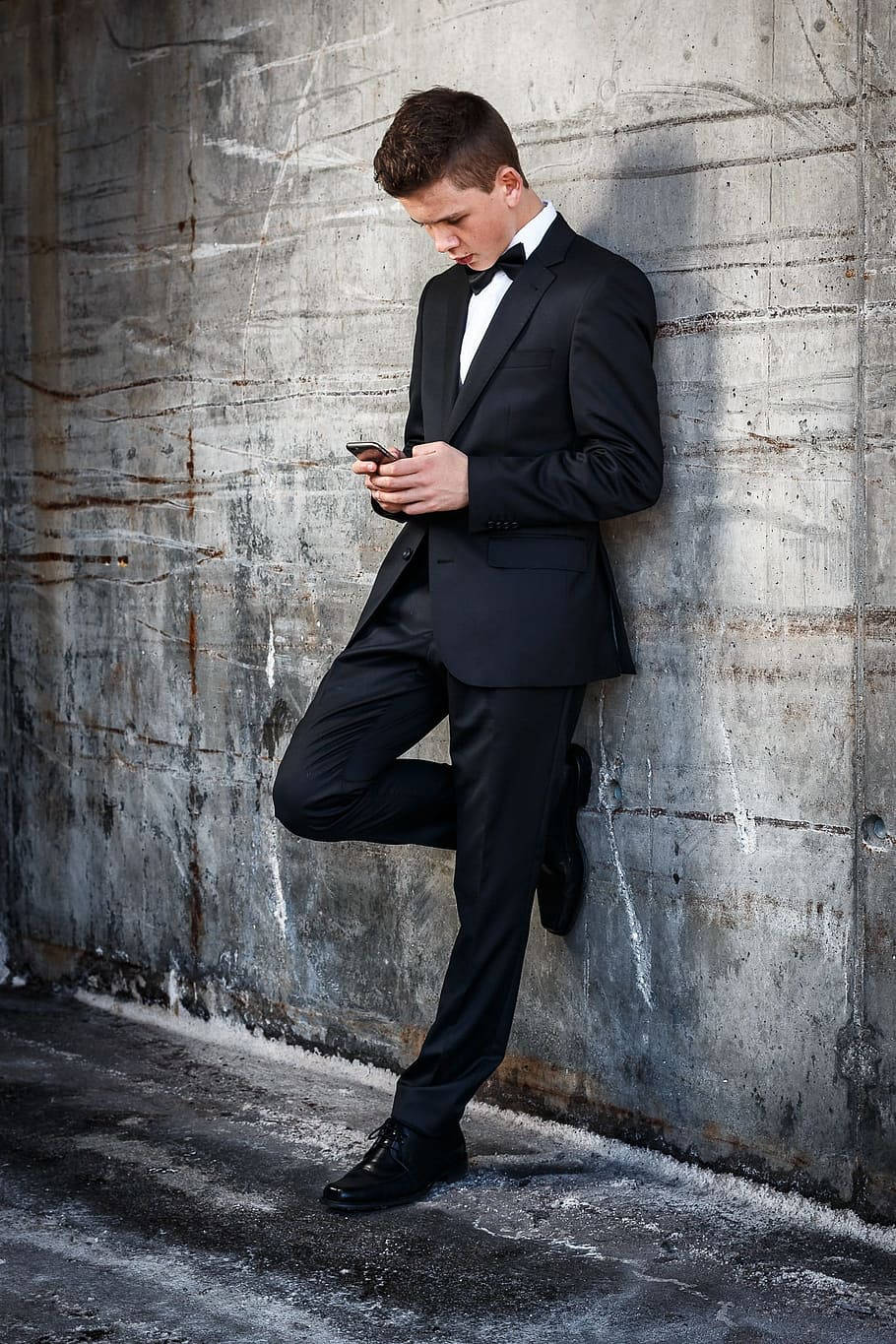 Guy In Tuxedo Against A Wall Background