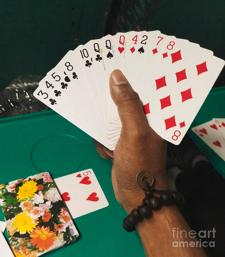 Hand Gripping Rummy Playing Cards