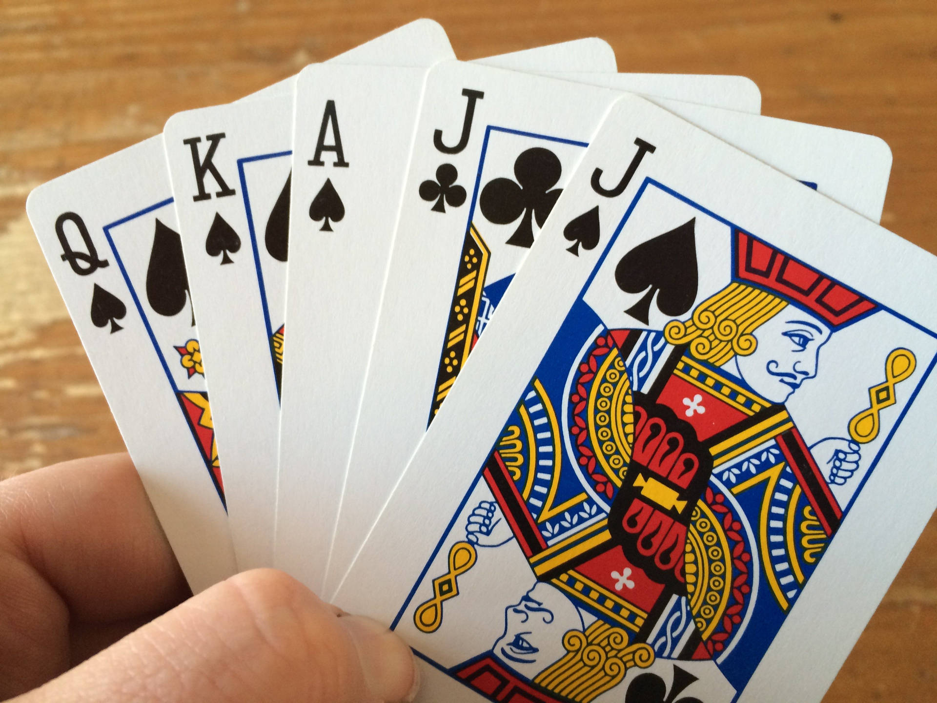 Hand Holding Five Euchre Playing Cards Background