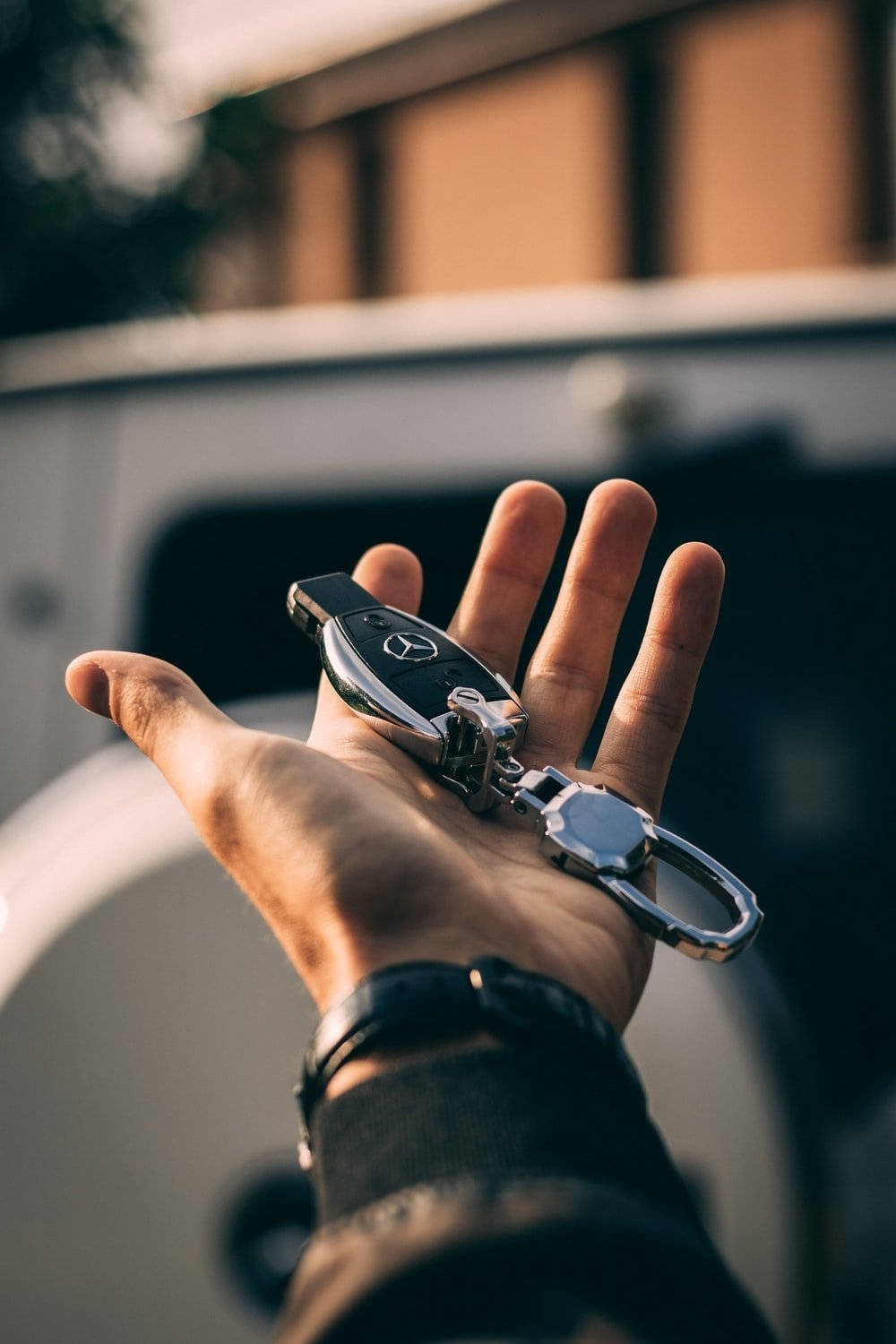 Hand Holding Mercedes Benz Car Key Background