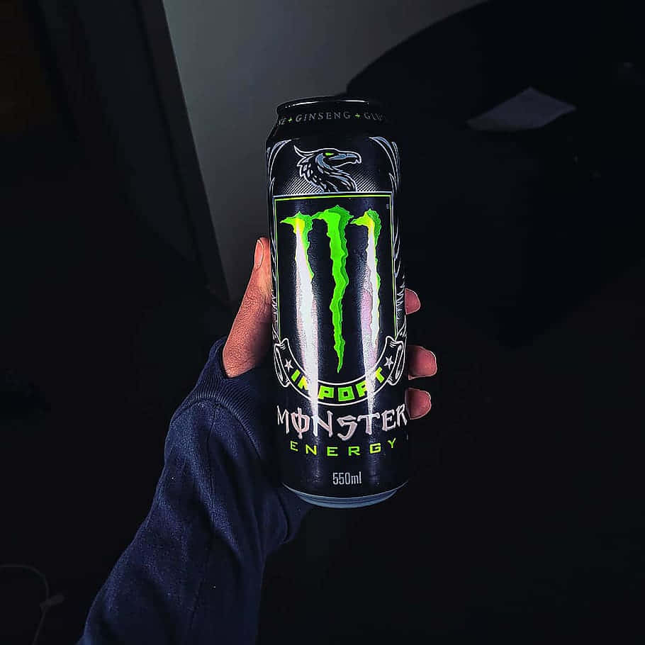Hand Holding Monster Energy Can Background