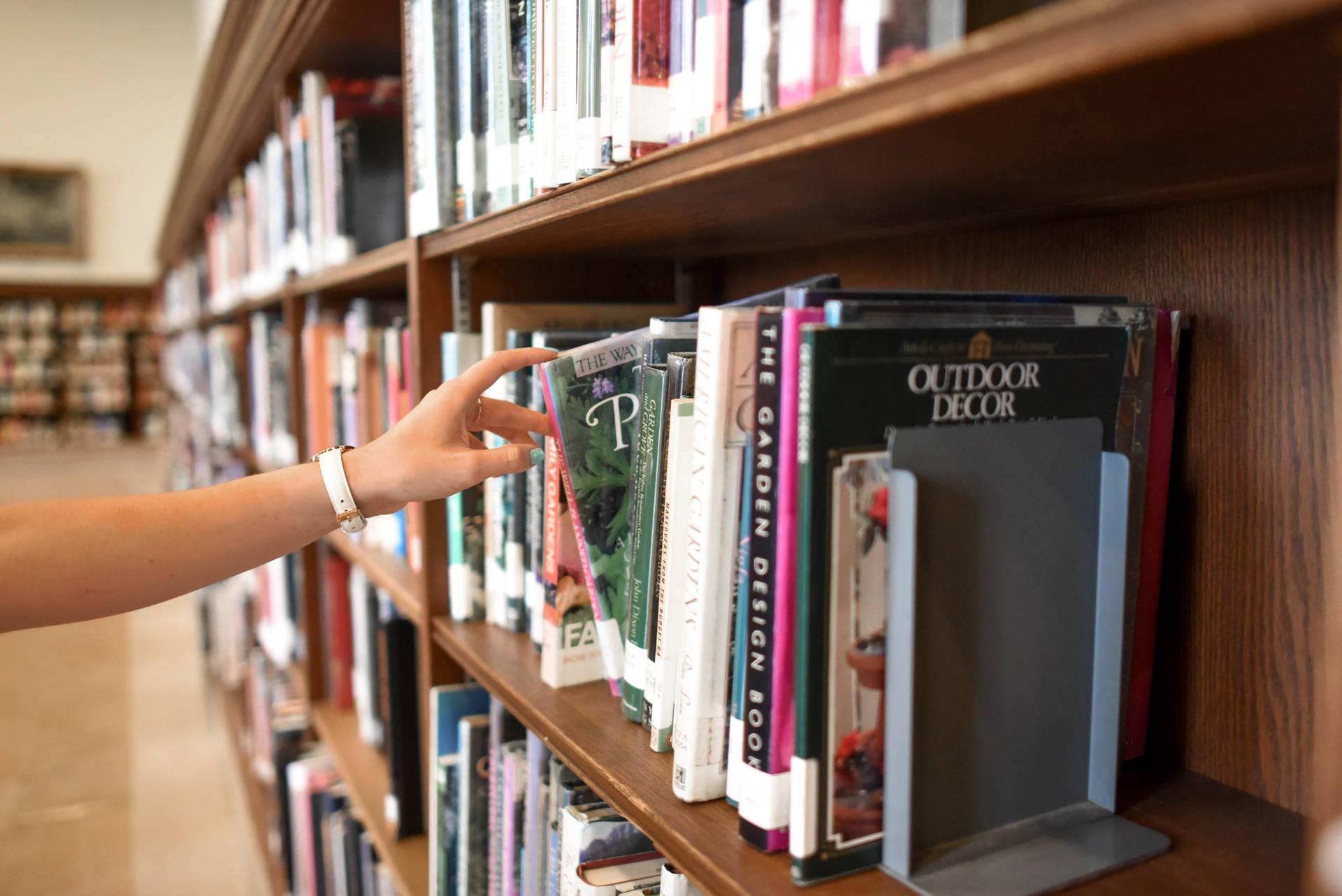 Hand Reaching To A Reference Book Background