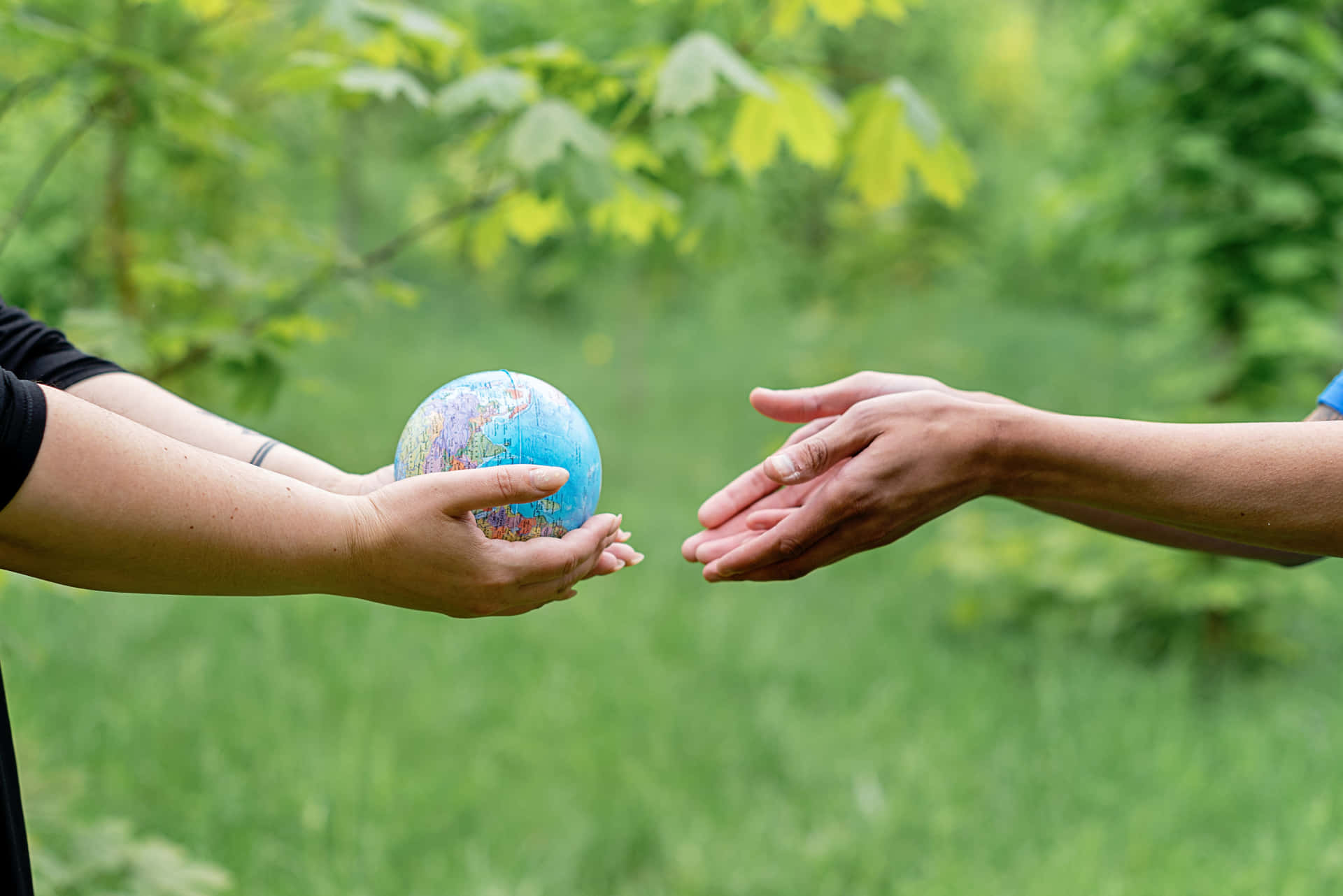 Hands Passing The Globe Background