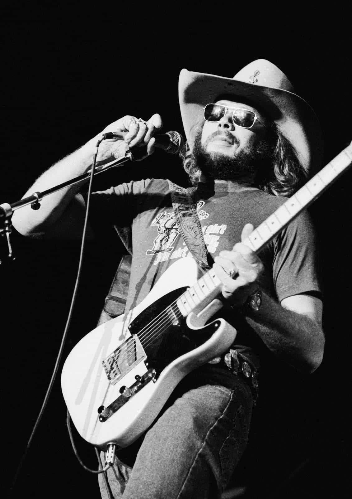 Hank Williams Jr Performing At A Live Music Concert Background