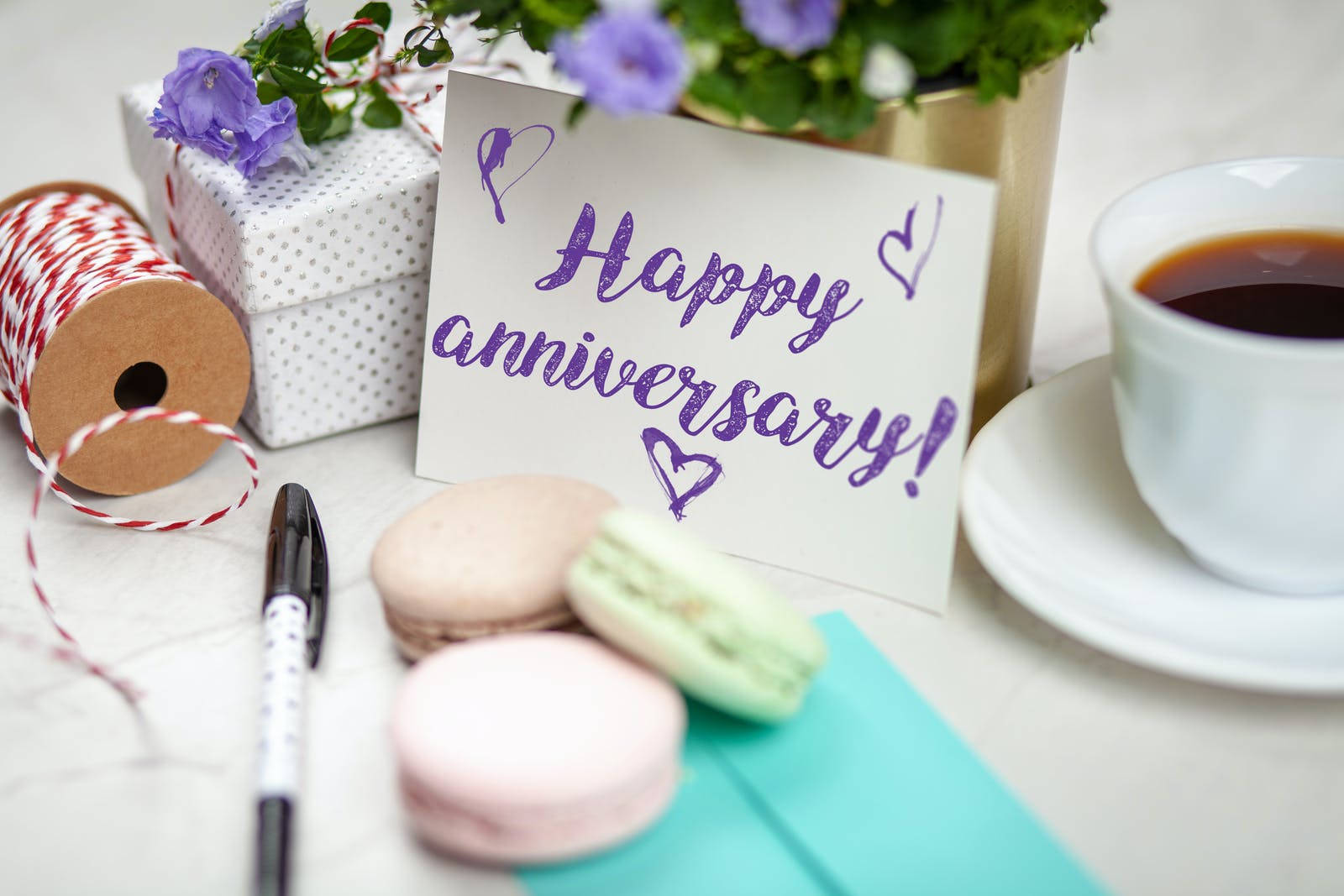 Happy Anniversary Signage With Macaroons Background