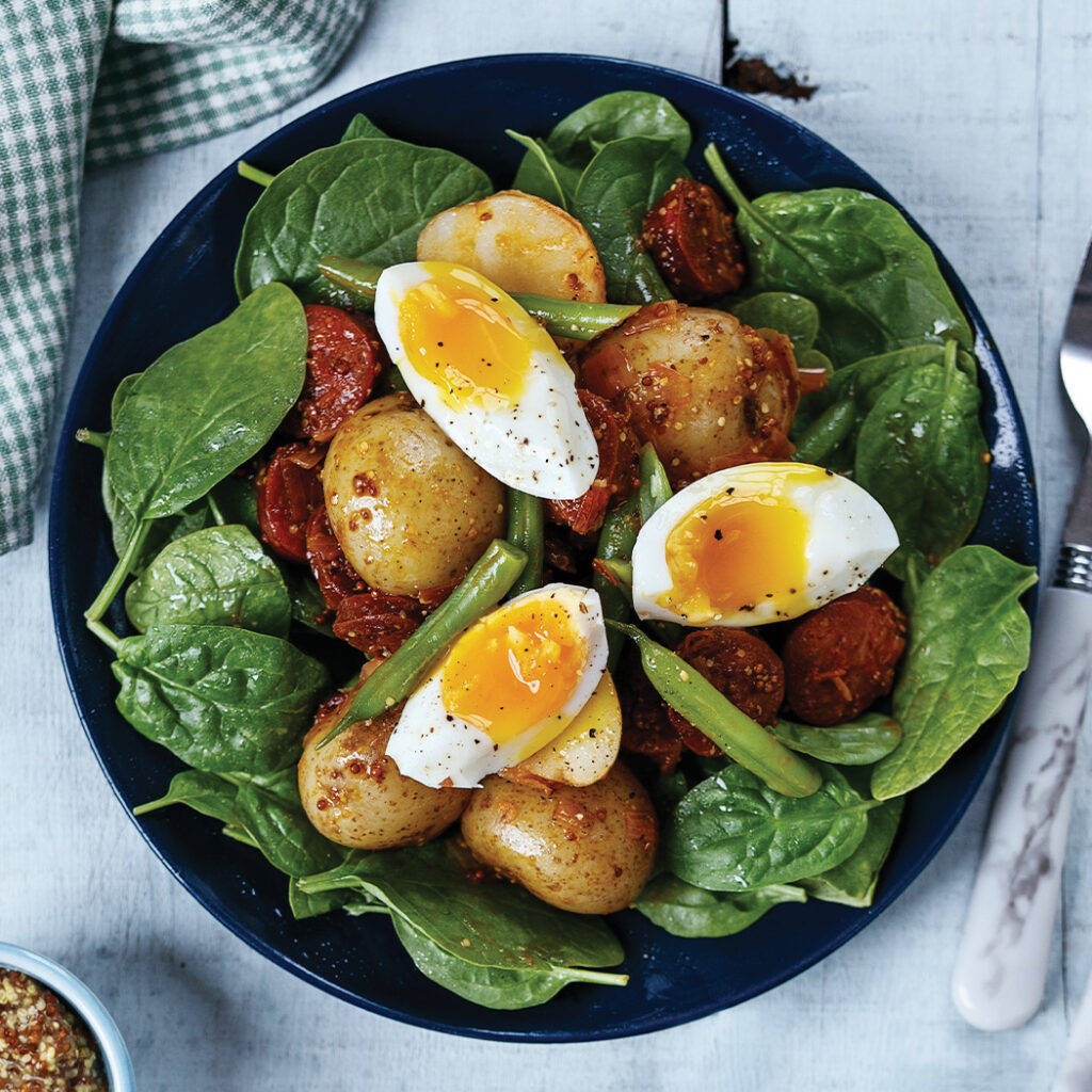 Hard Boiled Eggs With Sausages On A Bed Of Basil Background