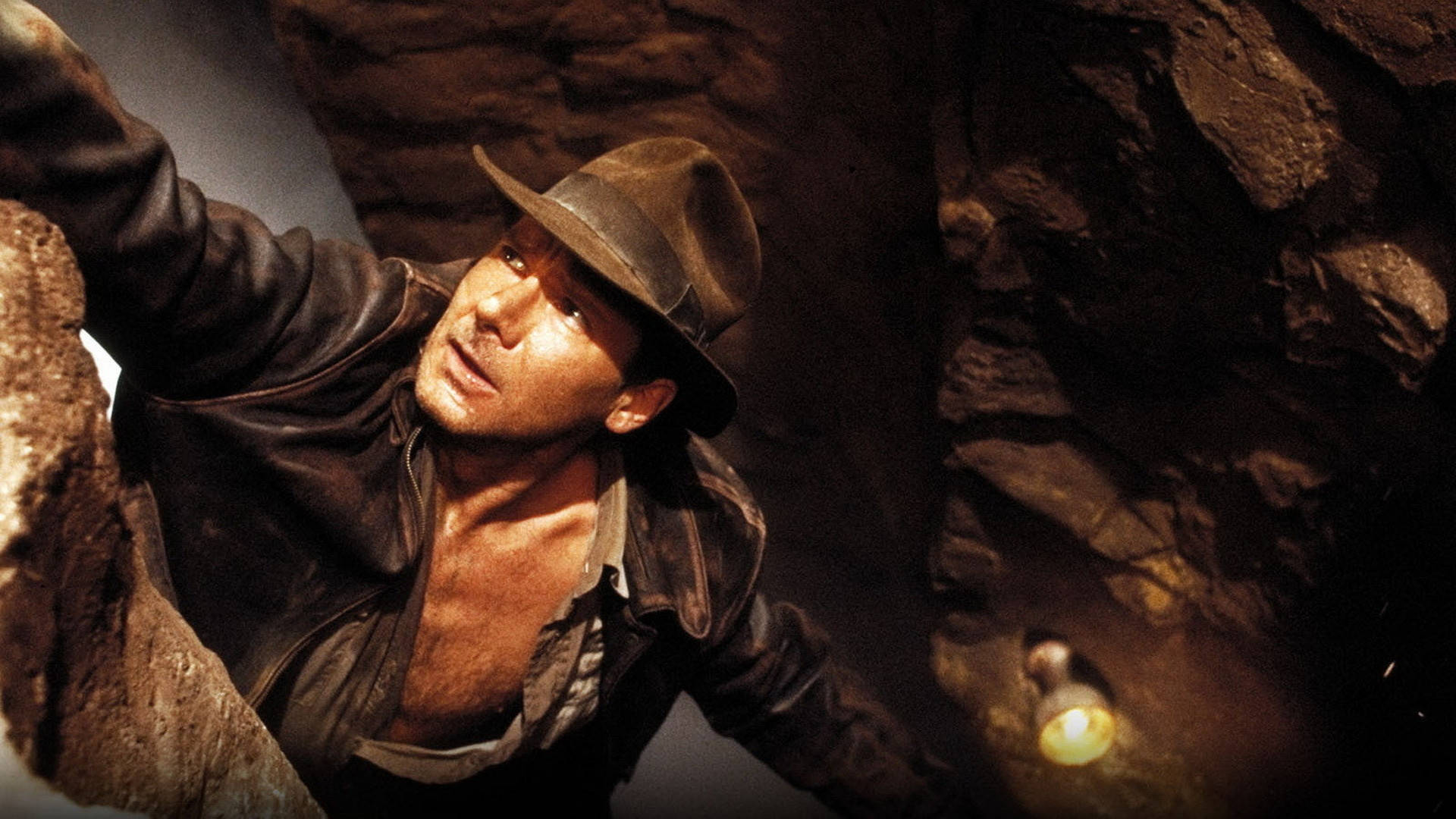 Harrison Ford As Indiana Jones On The Edge Of A Cliff Background