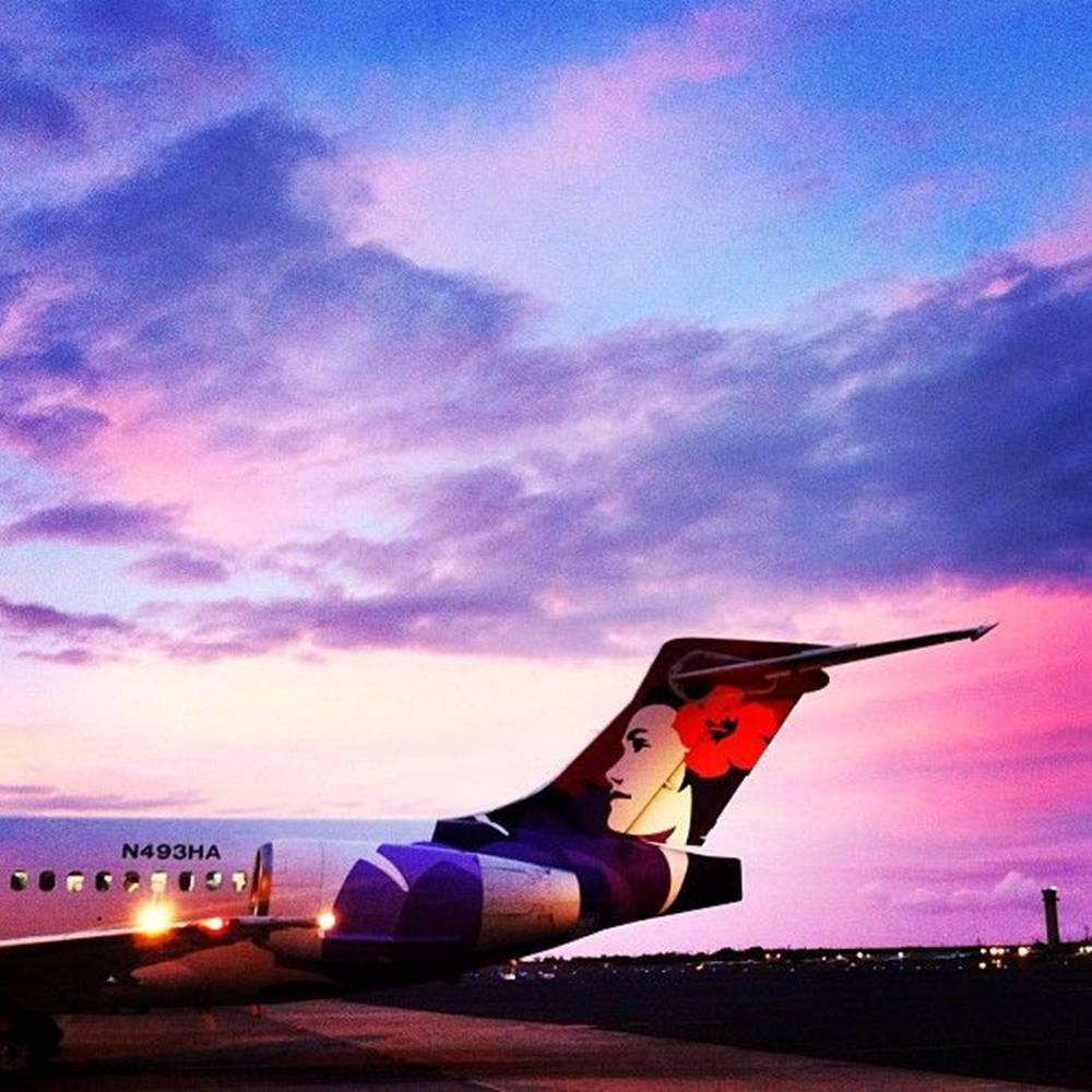 Hawaiian Airlines Jet Gliding Against The Purple Twilight Background