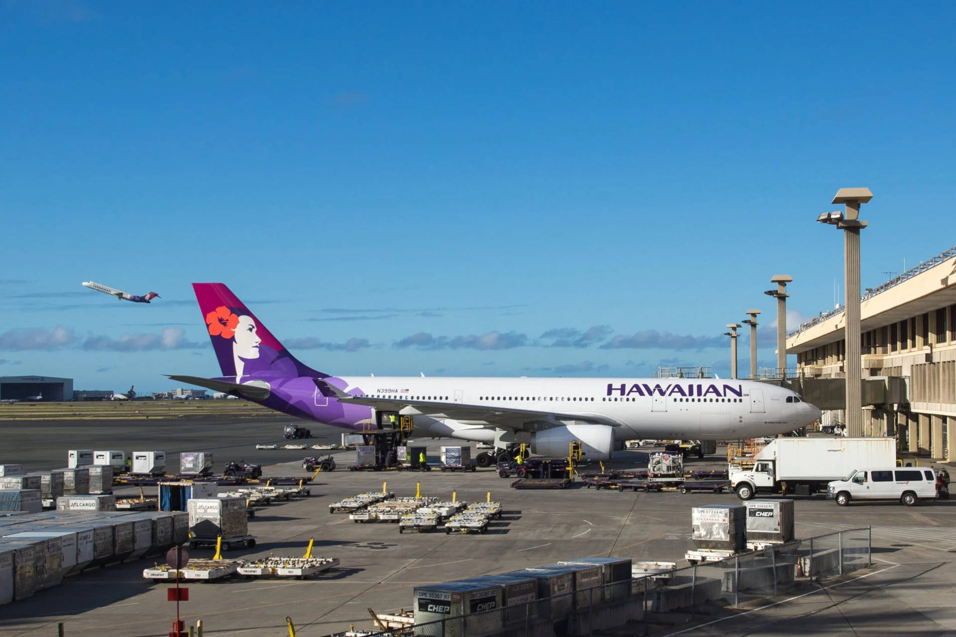 Hawaiian Airlines Plane Amidst A Busy Tarmac Background