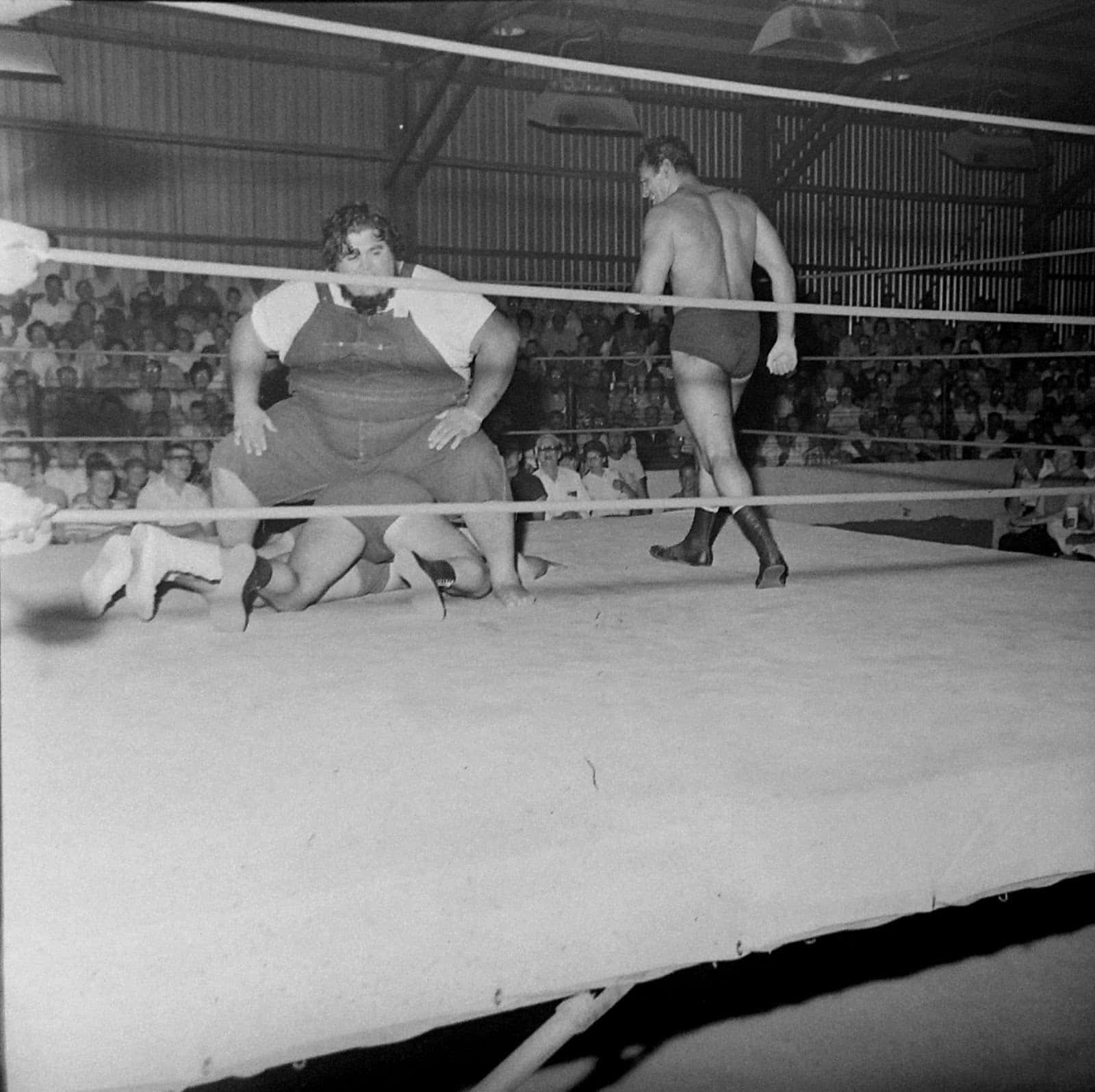 Haystacks Calhoun Versus Three Wrestlers In Fairgrounds Expo Background