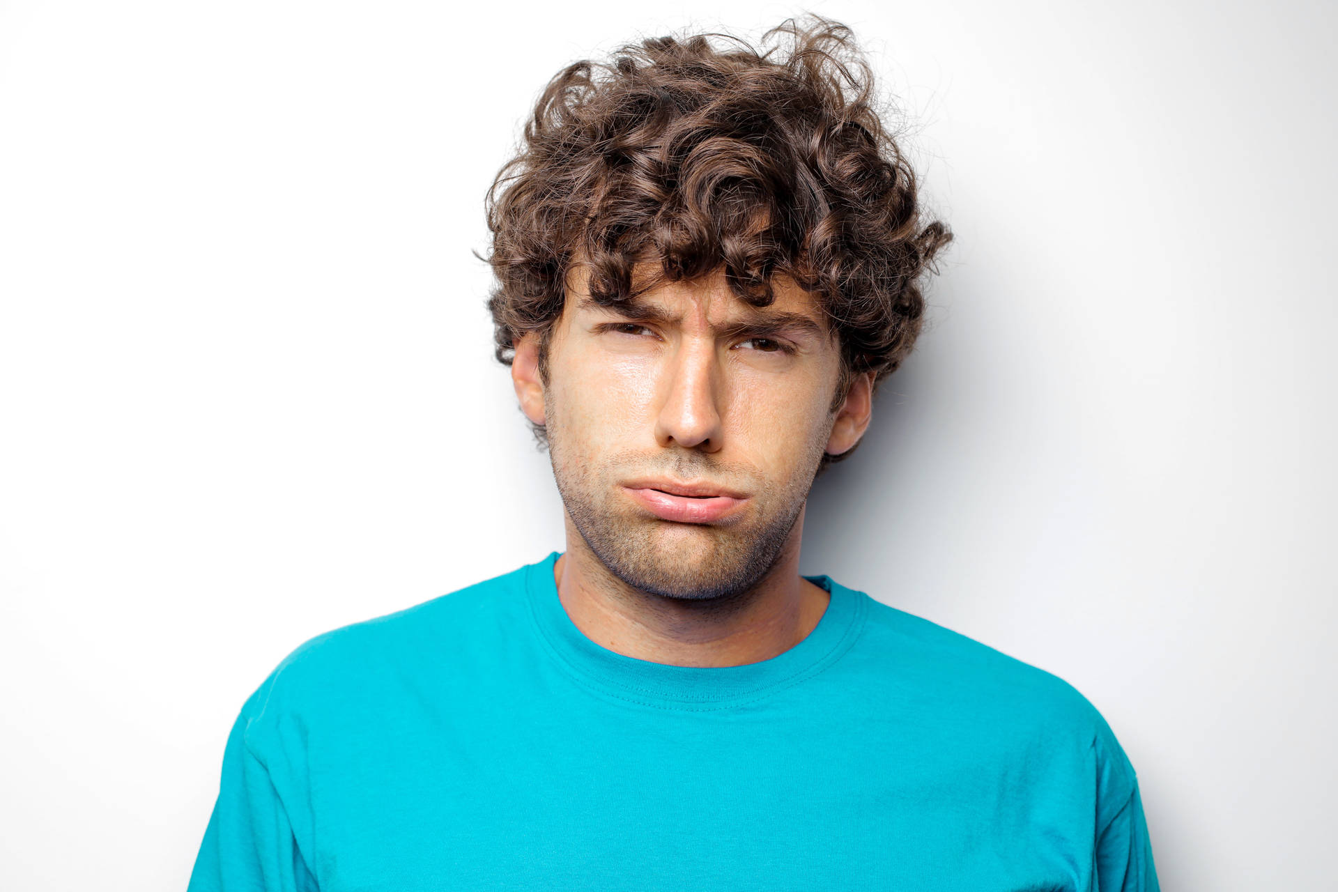 Headshot Of An Exhausted Man With Curly Hair Background