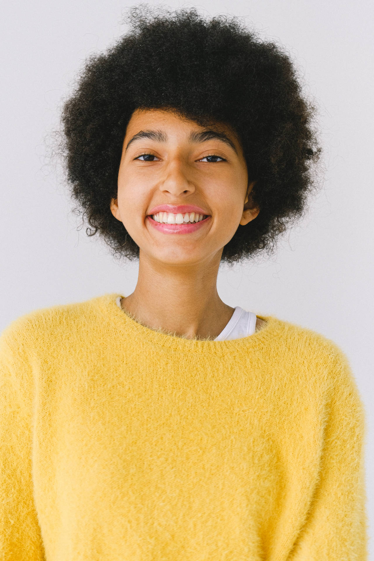 Headshot Of Black Woman In Yellow Knitted Top