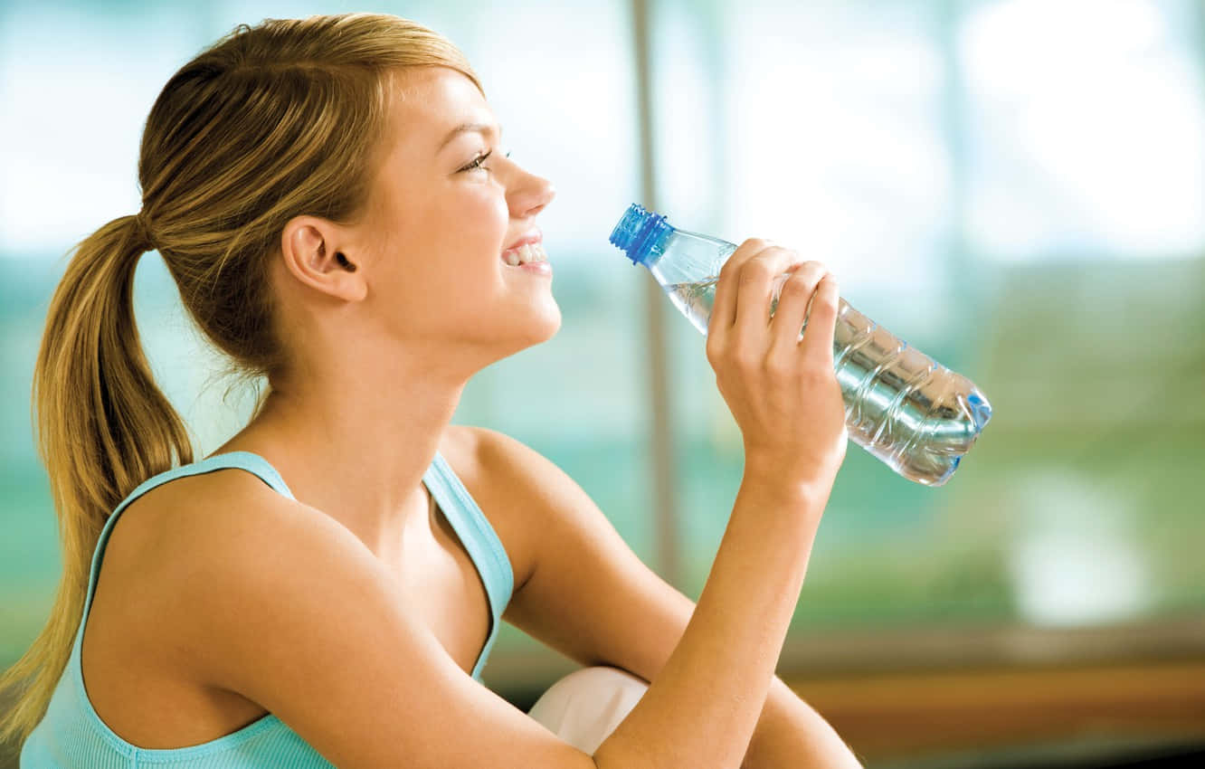 Health-conscious Woman Enjoying A Refreshing Drink Of Vital Water. Background