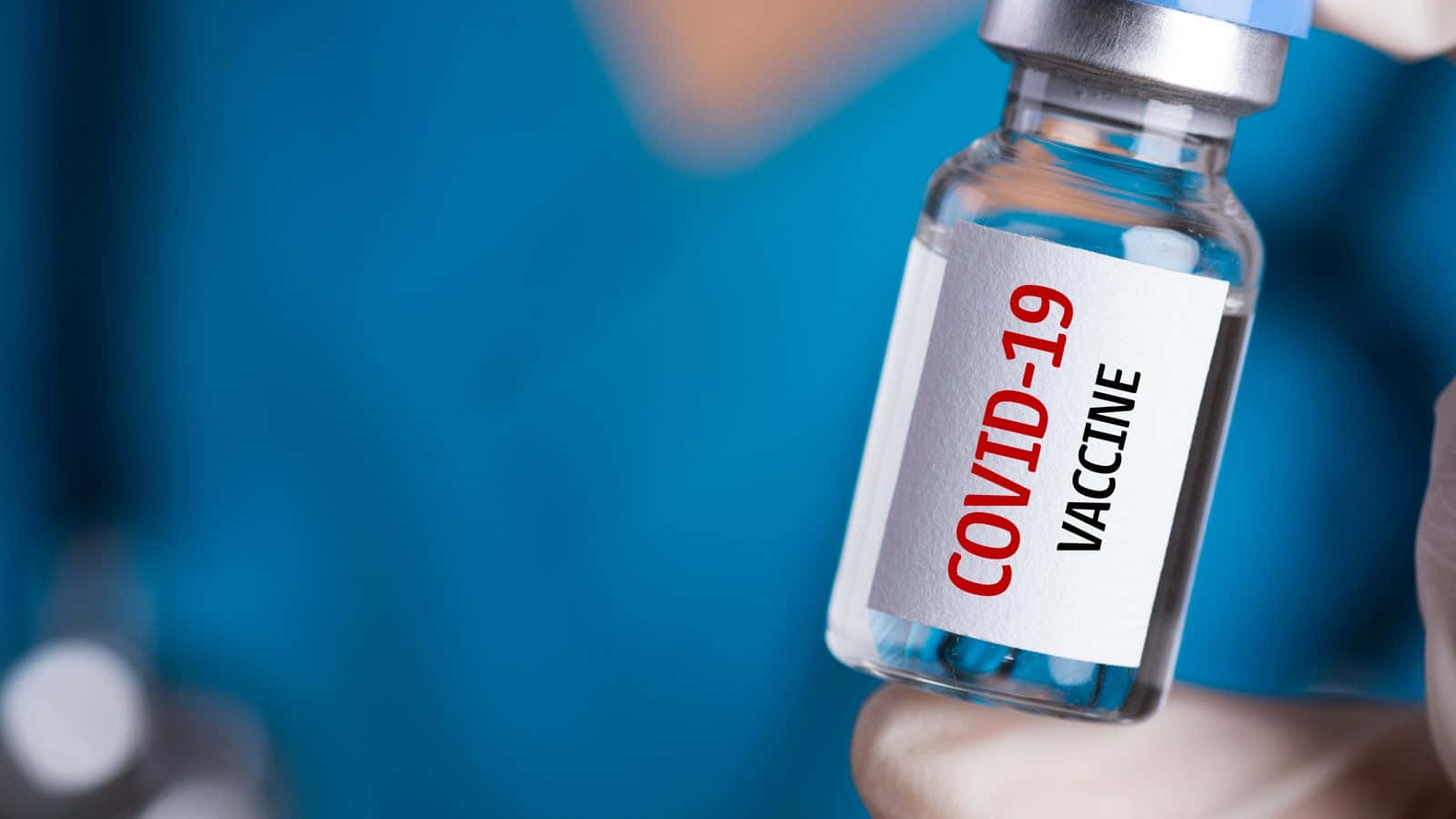 Healthcare Worker Holding A Dose Of Covid-19 Vaccine In A Vial. Background