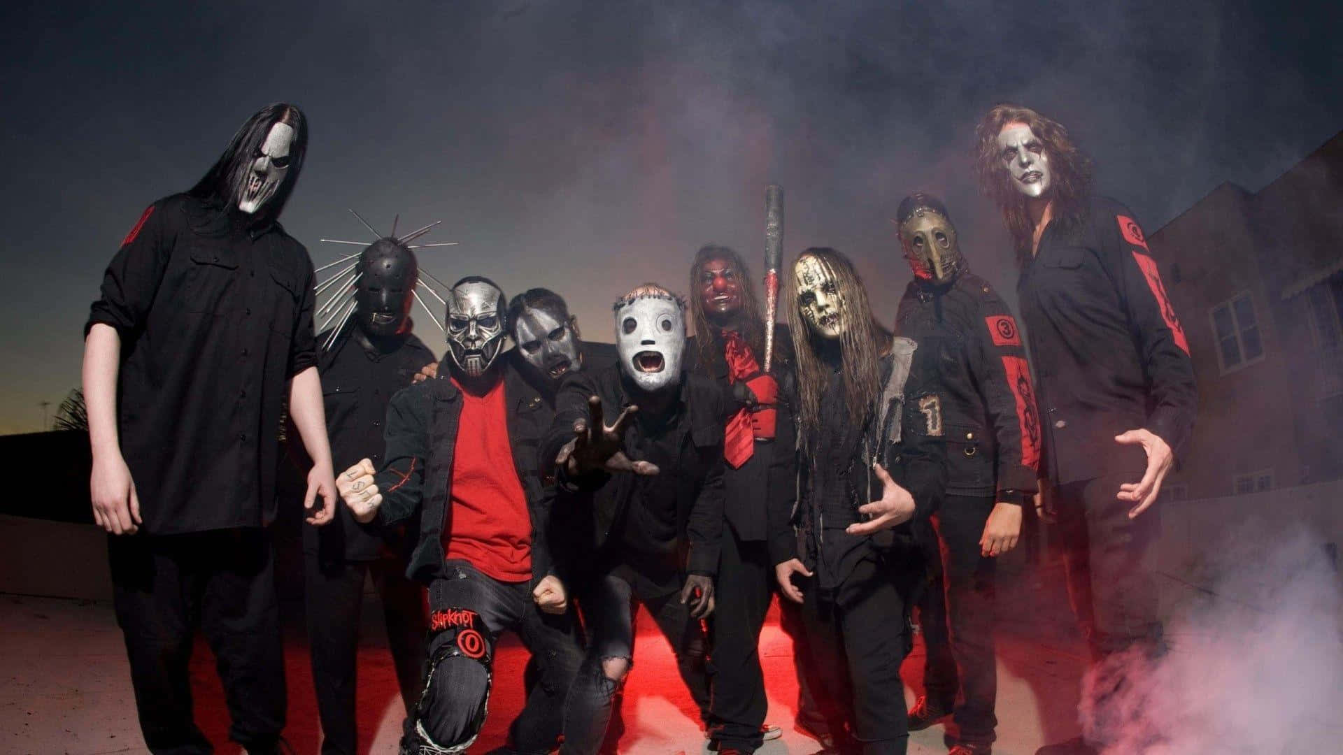 Heavy Metal Band Slipknot In Dark Attire Performing On Stage Background