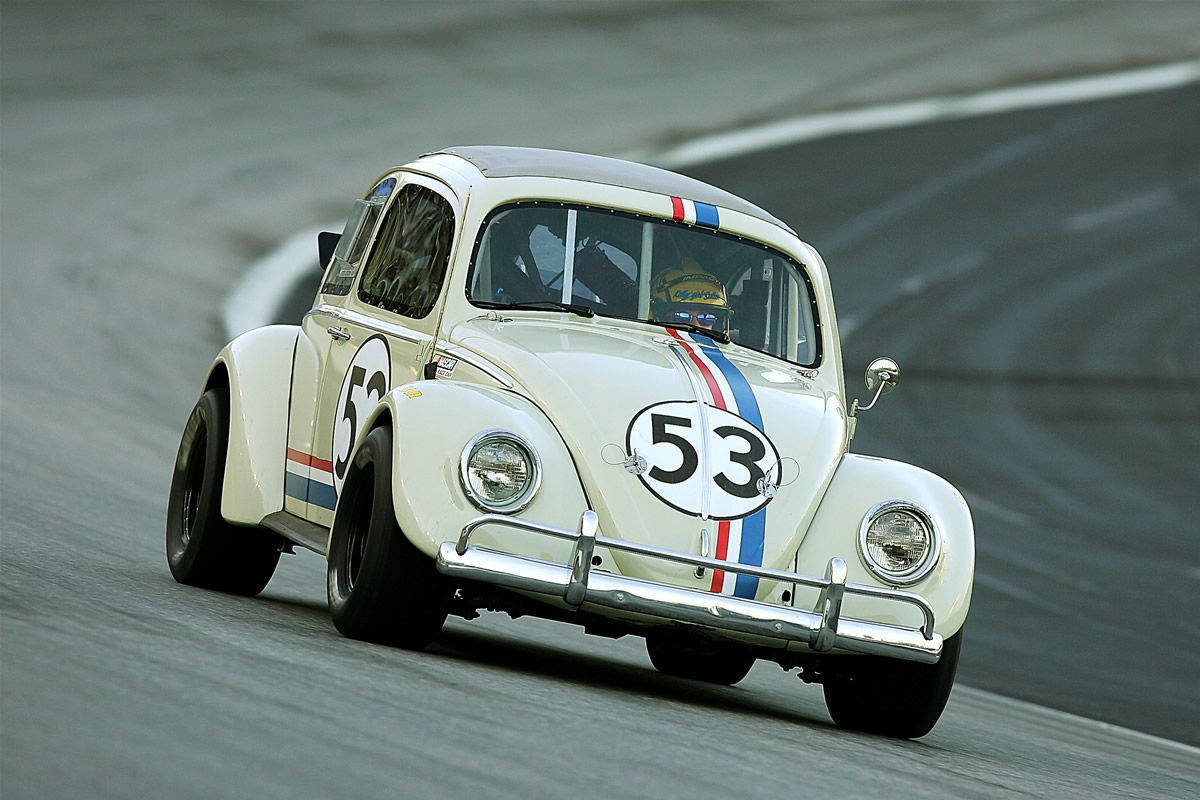Herbie Fully Loaded Driving On Racetrack Background