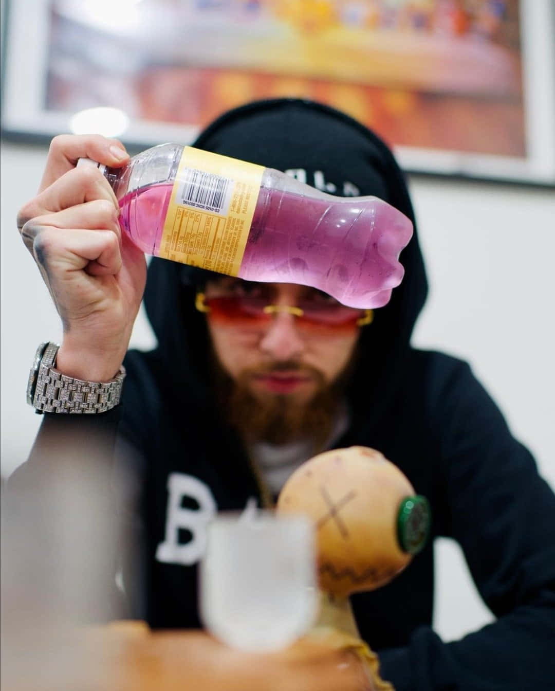 Herencia De Patrones Showing A Purple Drink Background