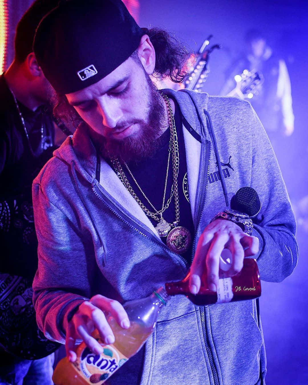 Herencia De Patrones Vocalist Pouring A Drink Background