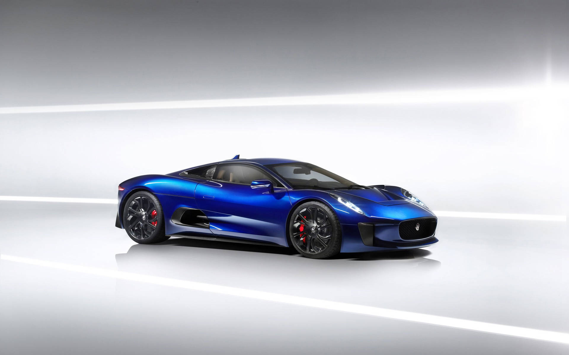 High Performance And Style On The Road In The Electric Blue Jaguar Background