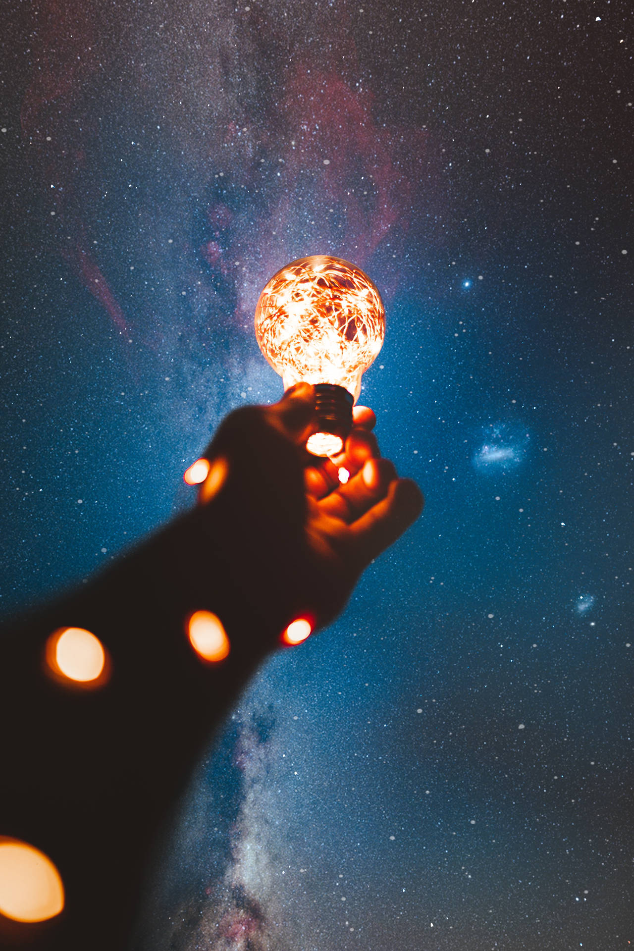 High Resolution Star Hand Holding Light Bulb Background