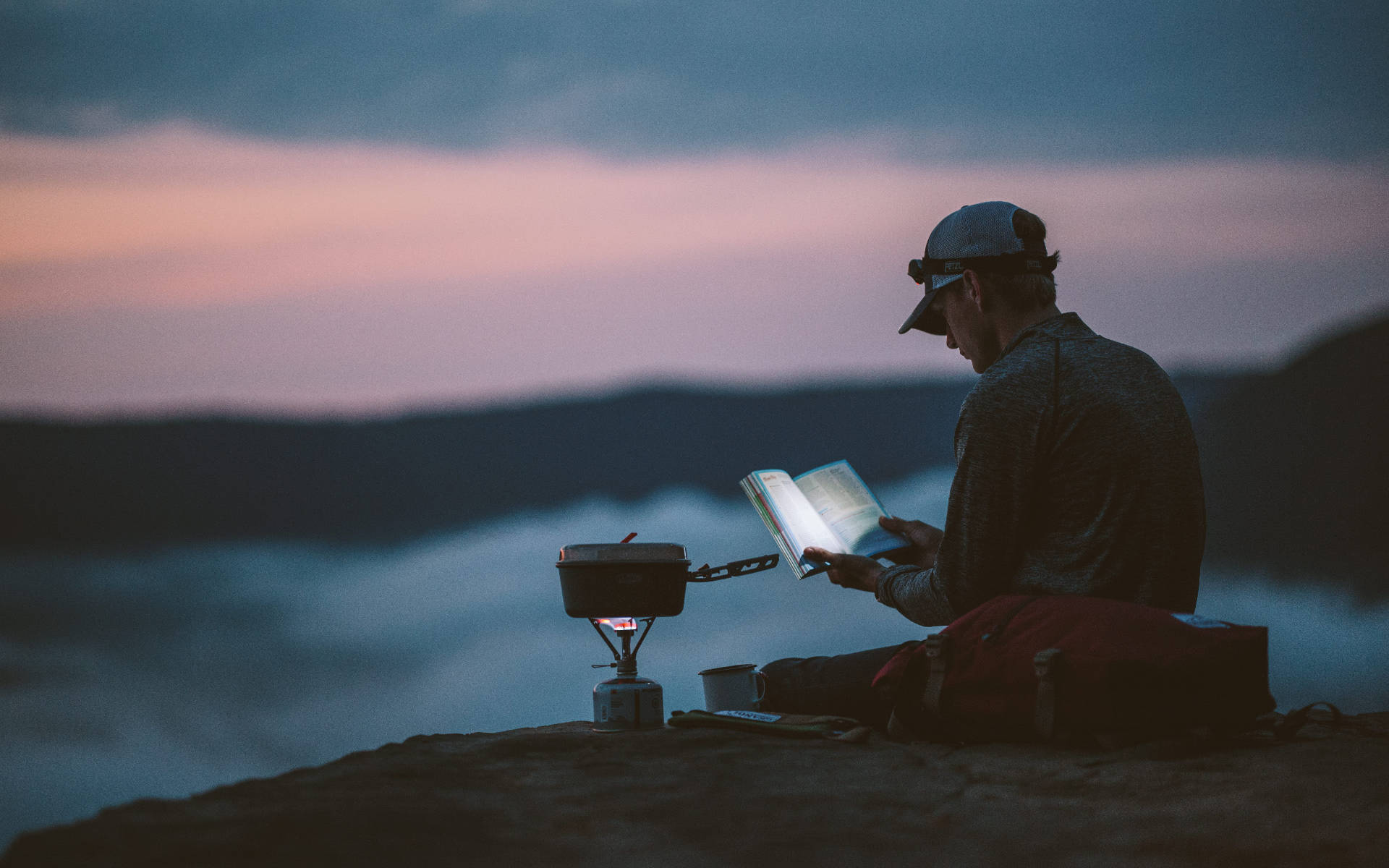 Hiker Reading Book In Mountain