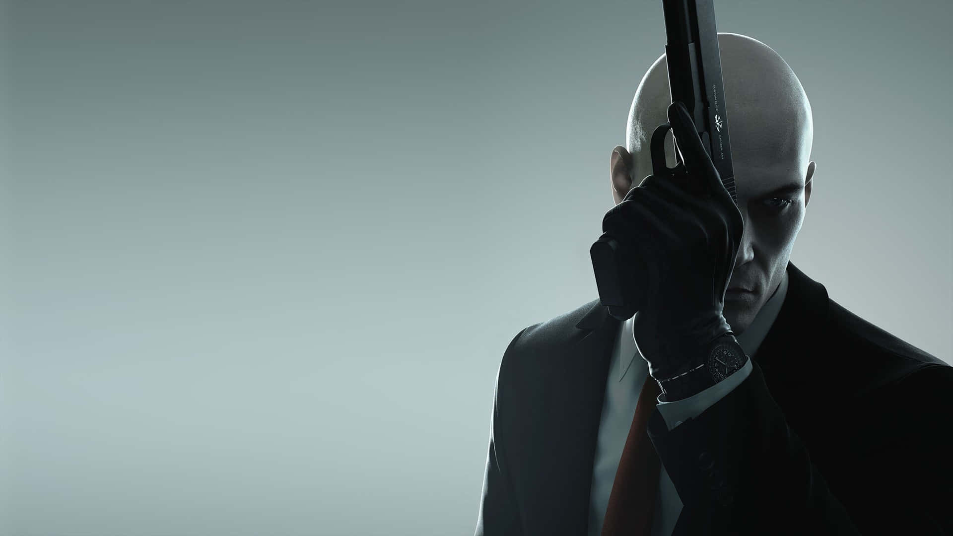 Hitman Holding Up Gun Desktop Background