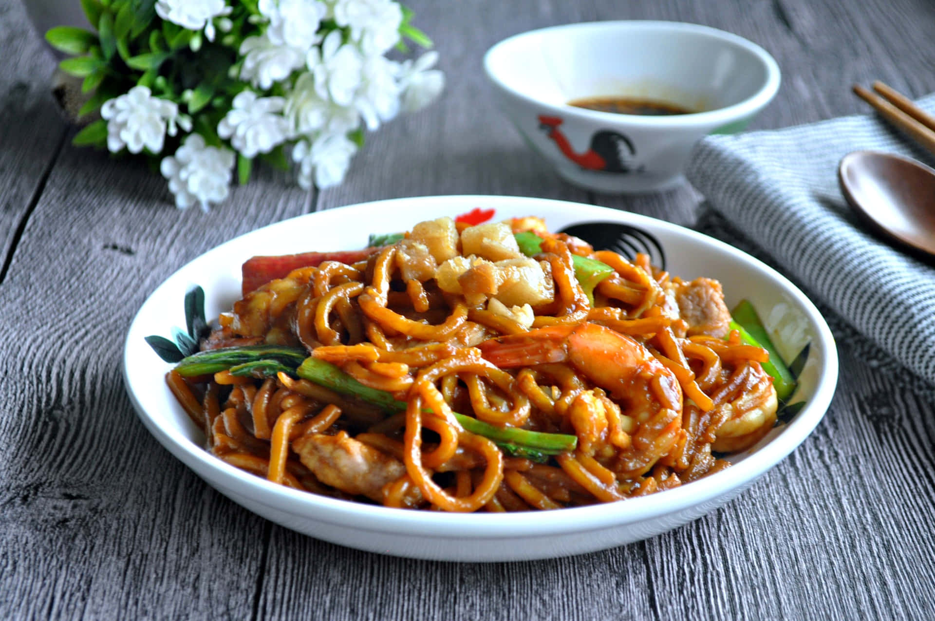 Hokkien Mee On Grey Table With White Flowers Background