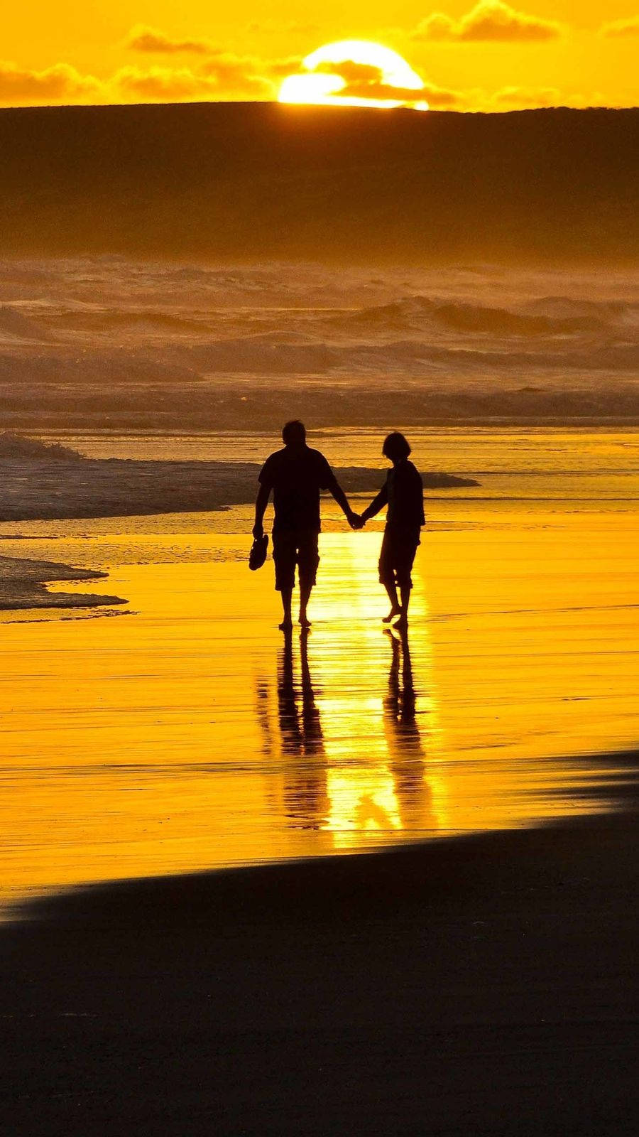 Holding Hands At Sunset On The Beach