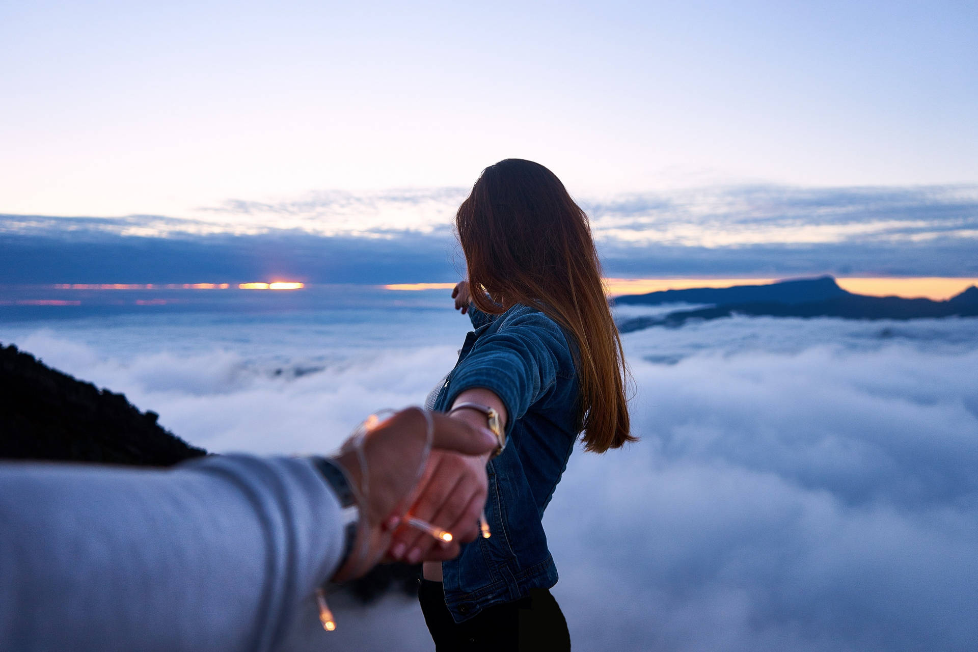 Holding Hands In Sea Of Clouds Background