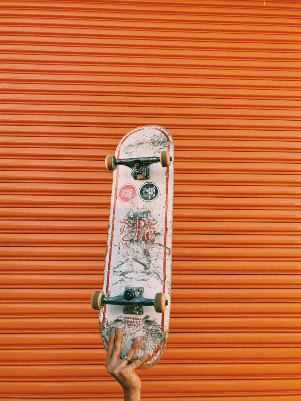 Holding Up Retro Skateboard Orange Background