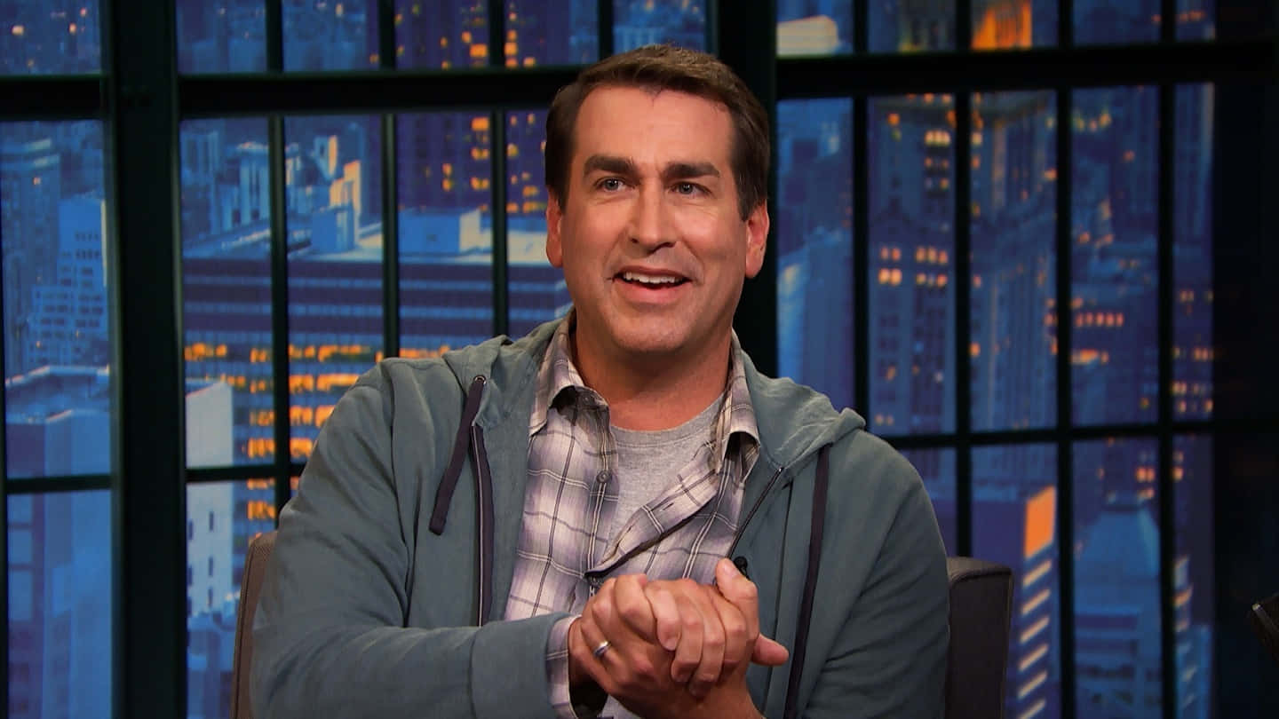 Hollywood Comedian Rob Riggle Glowing In Spotlight Background