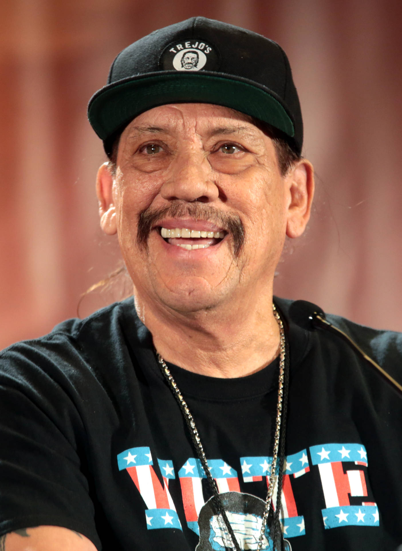 Hollywood Icon Danny Trejo Sporting A Vote Shirt Background