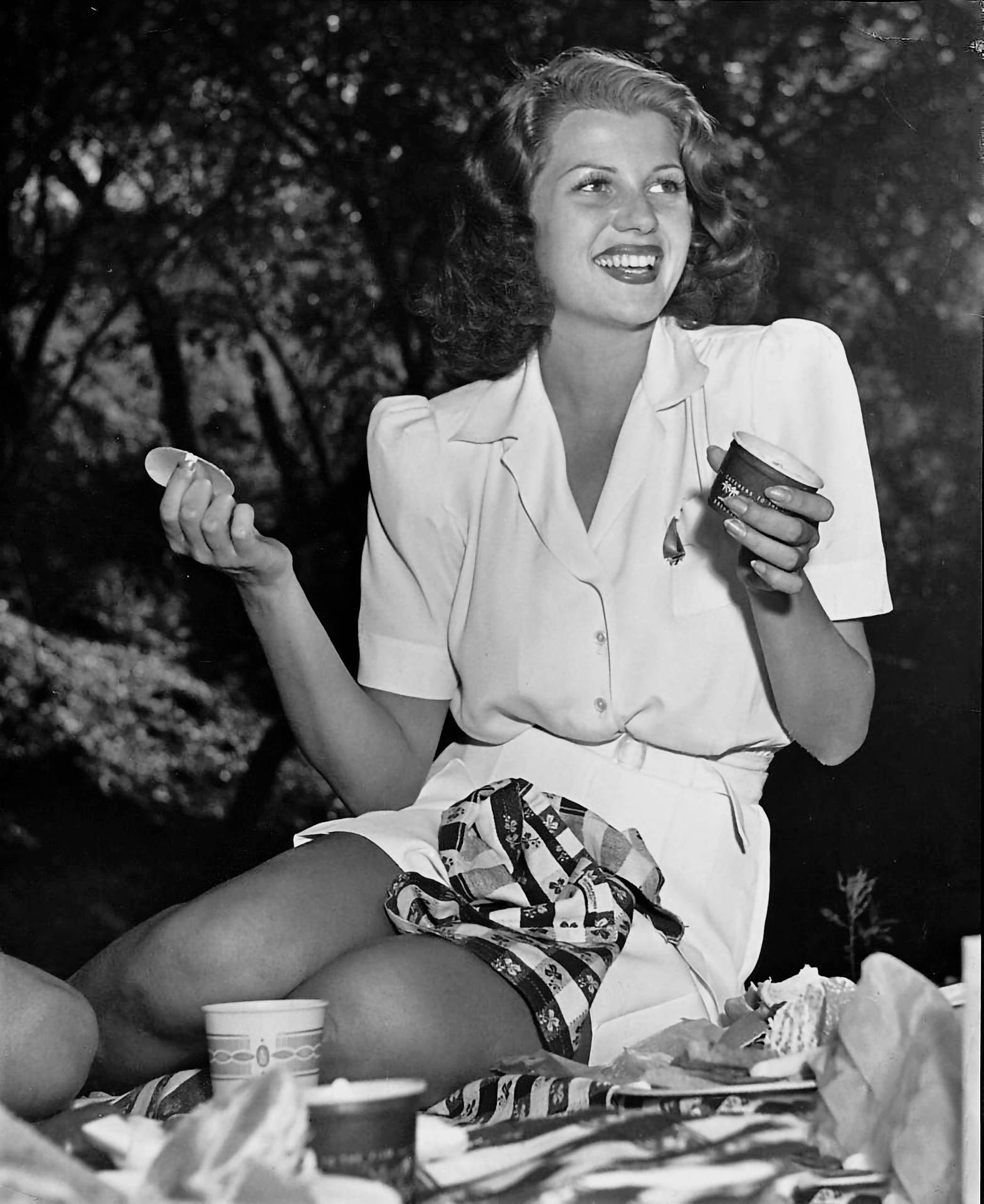 Hollywood Icon Rita Hayworth In A Picnic Outfit Background