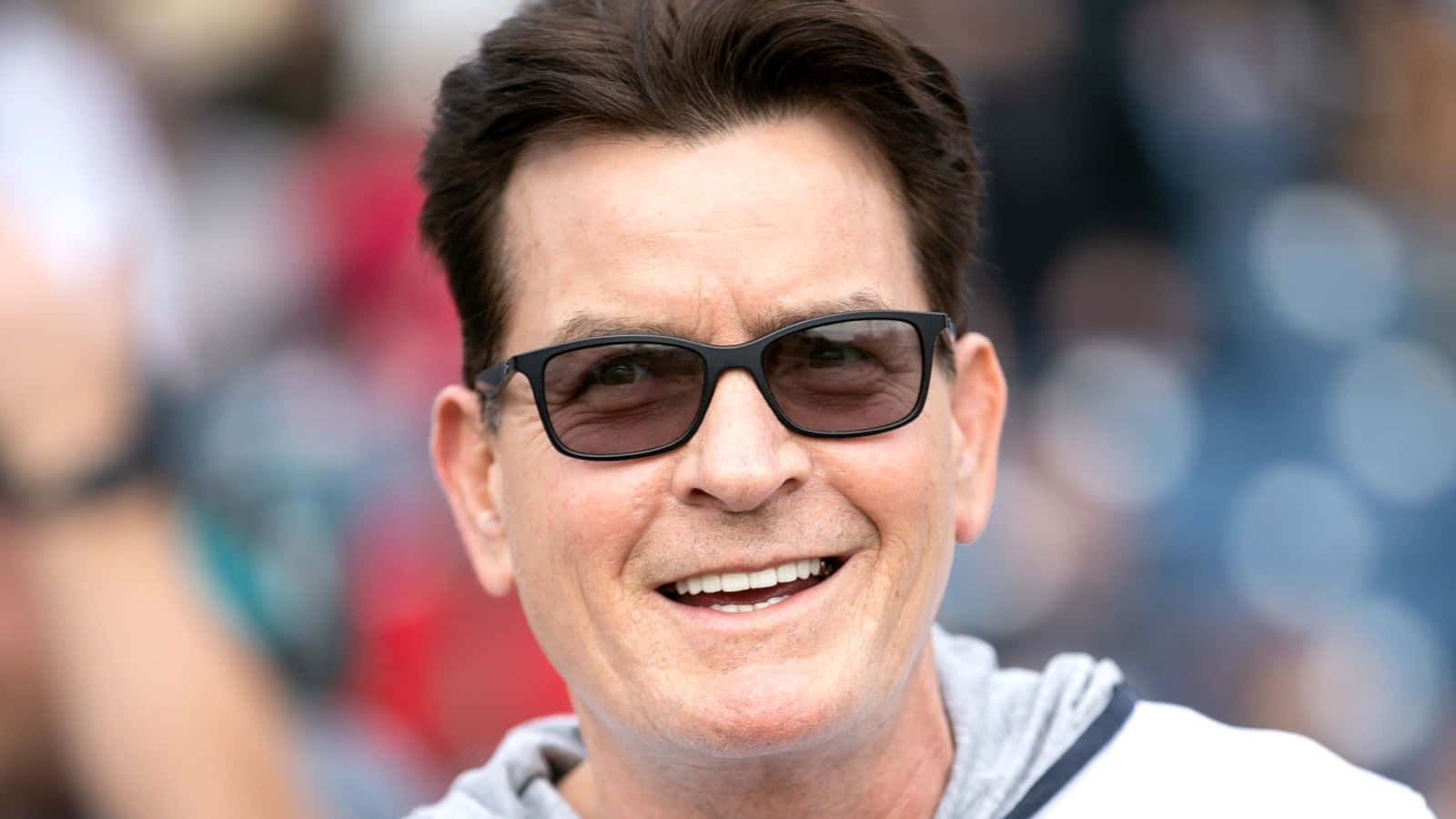 Hollywood Legend, Charlie Sheen In A Captivating Portrait Background
