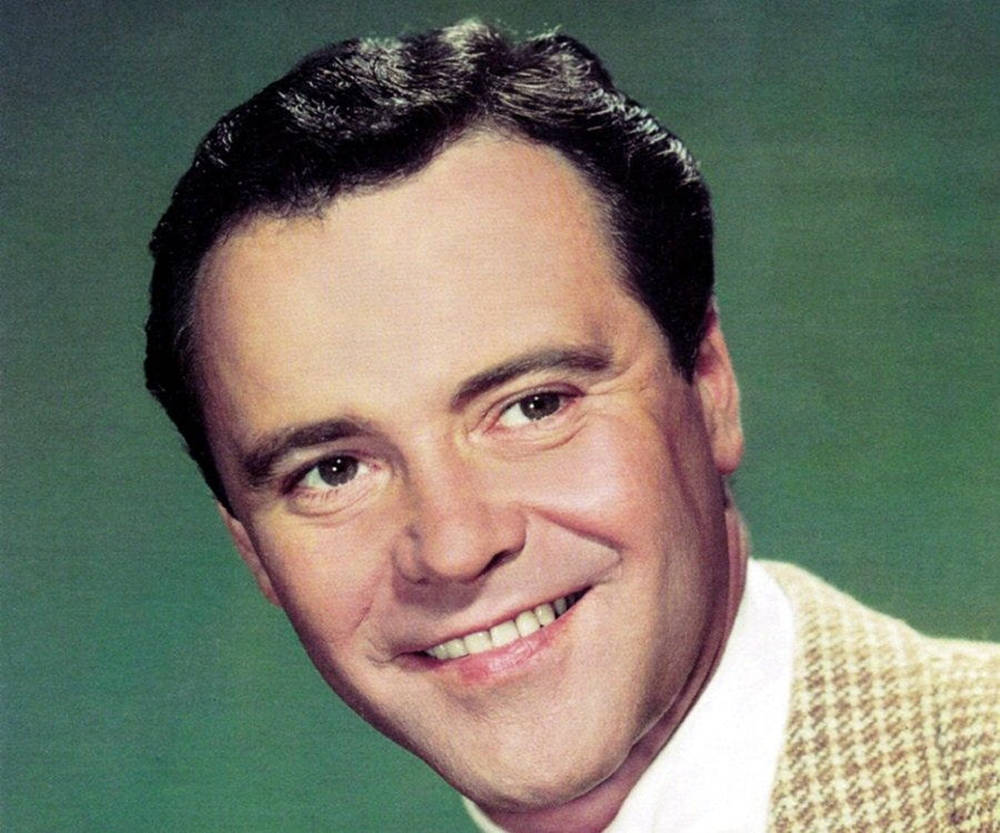 Hollywood Legend Jack Lemmon Posing Confidently In Front Of A Green Background Background