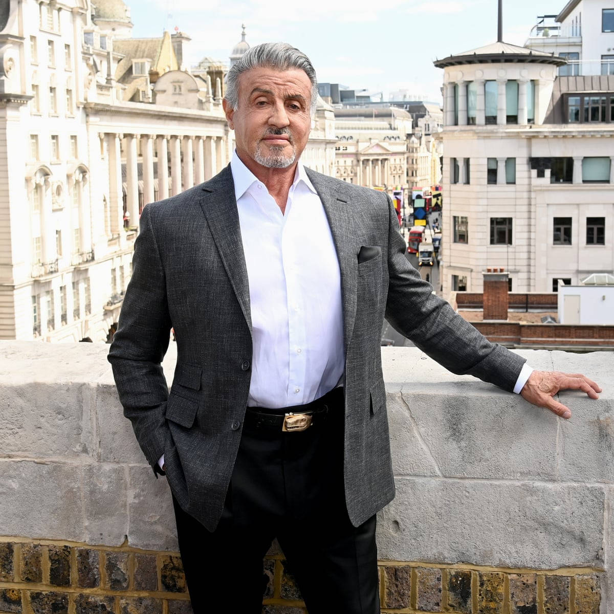 Hollywood Legend Sylvester Stallone Leaning On Concrete Wall Background