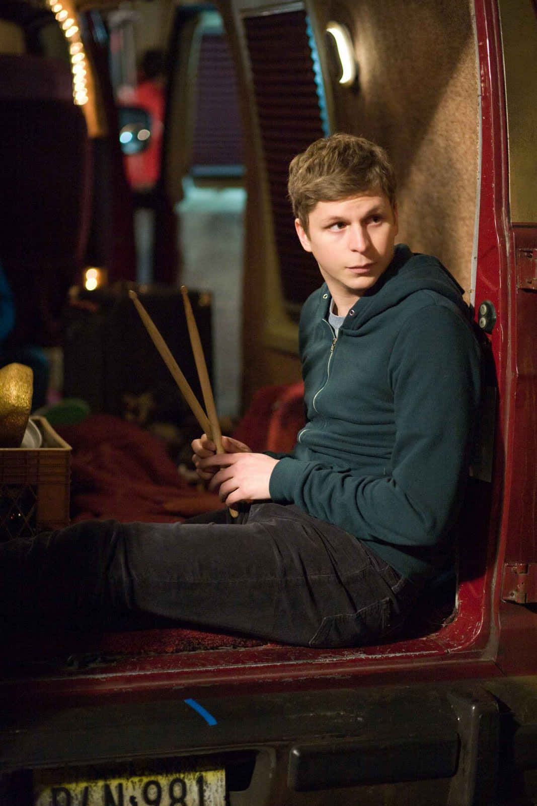 Hollywood Young Actor, Michael Cera Standing With A Slight Smile Background