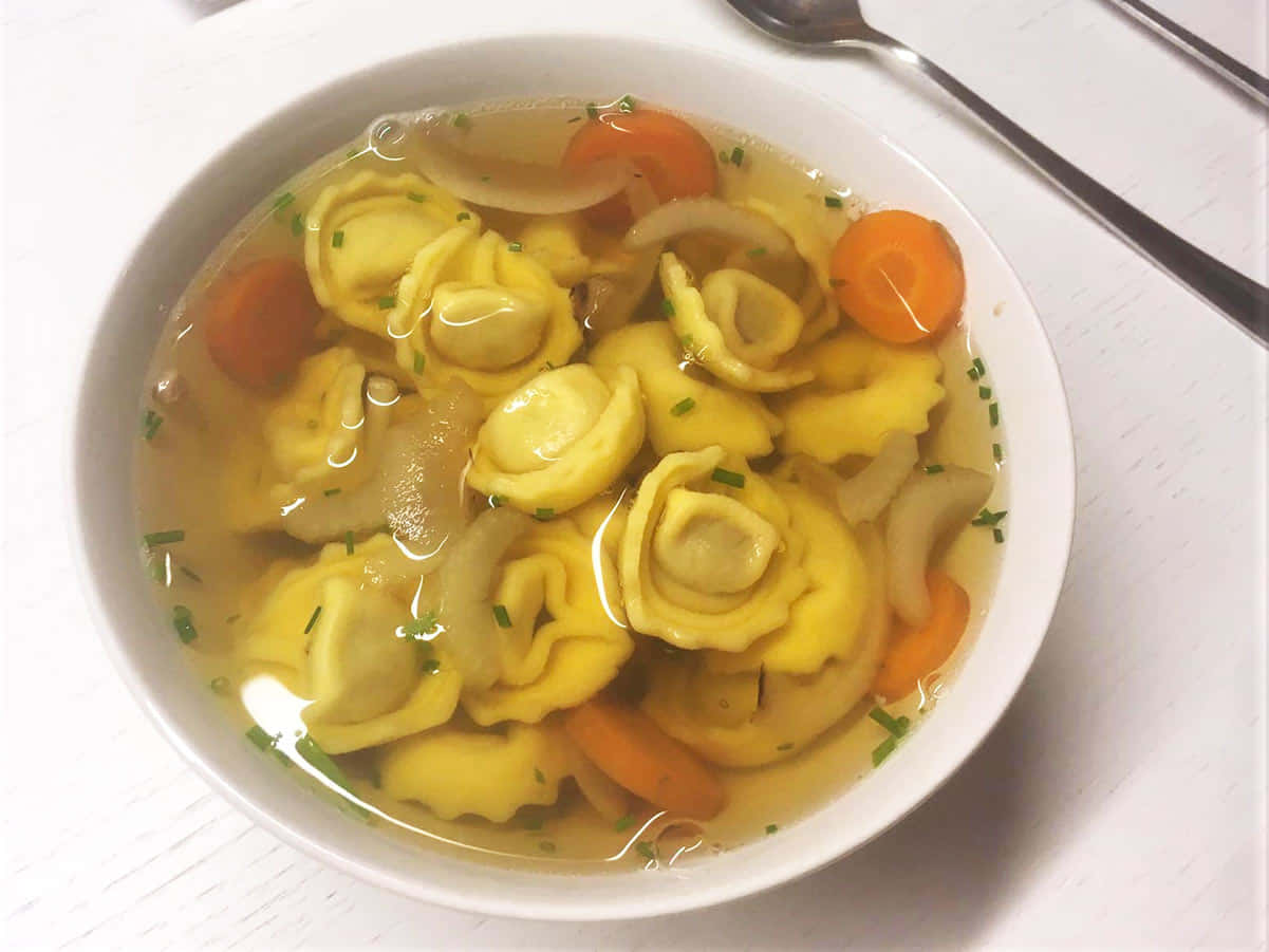 Homemade Tortellini In Brodo With Carrots Background