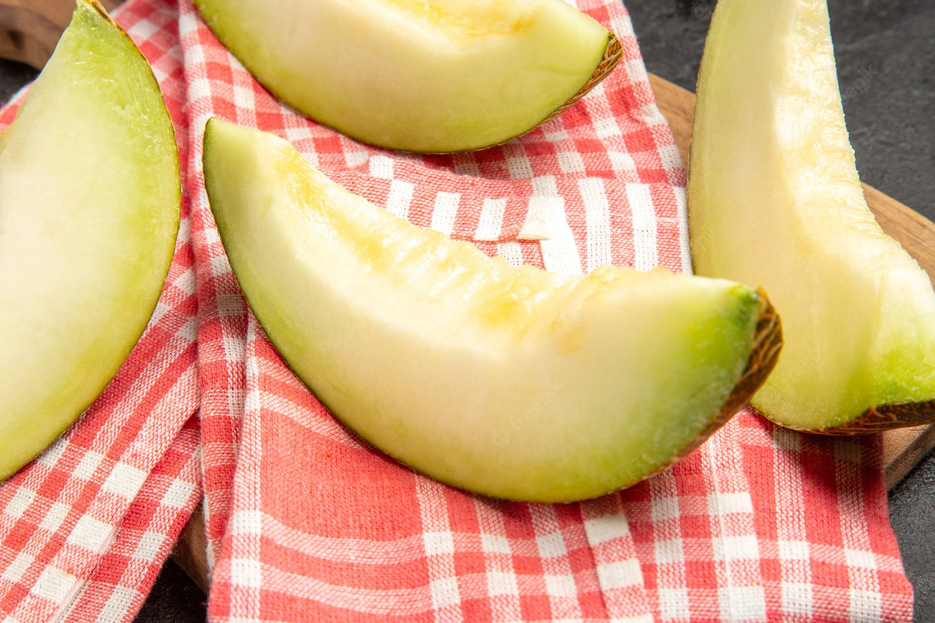 Honeydew Melon Slices On Red Blankets Background