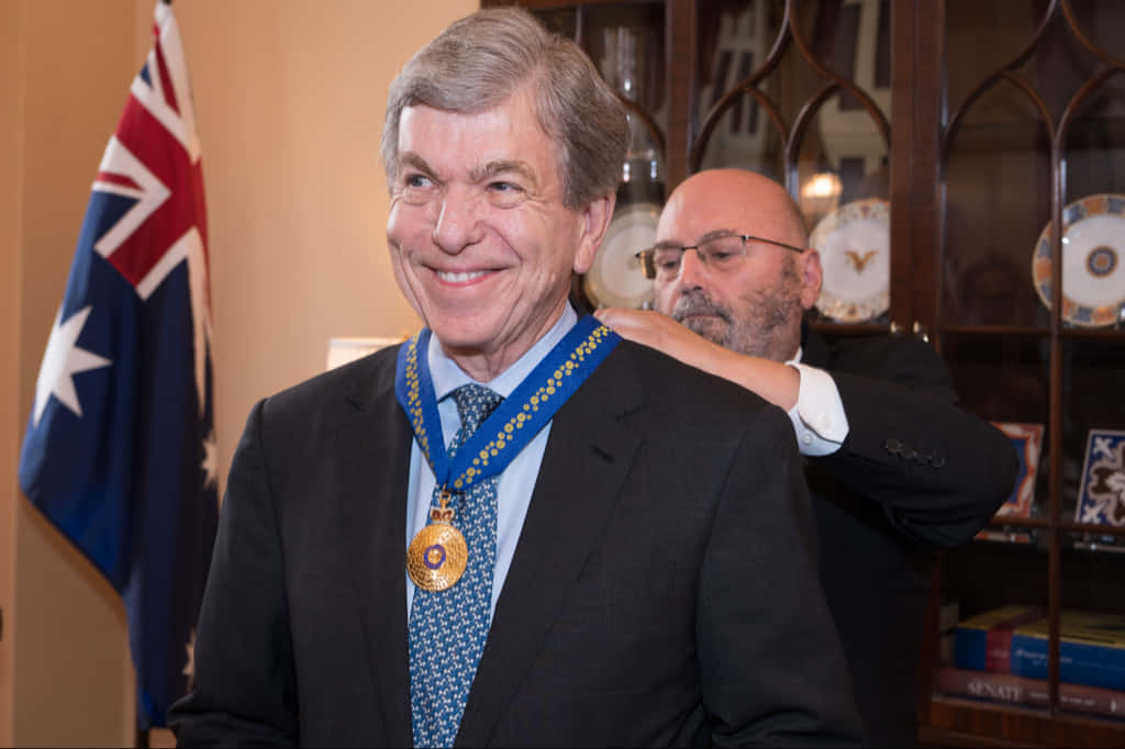 Honorable Senator Roy Blunt Holding A Prestigious Medal Background
